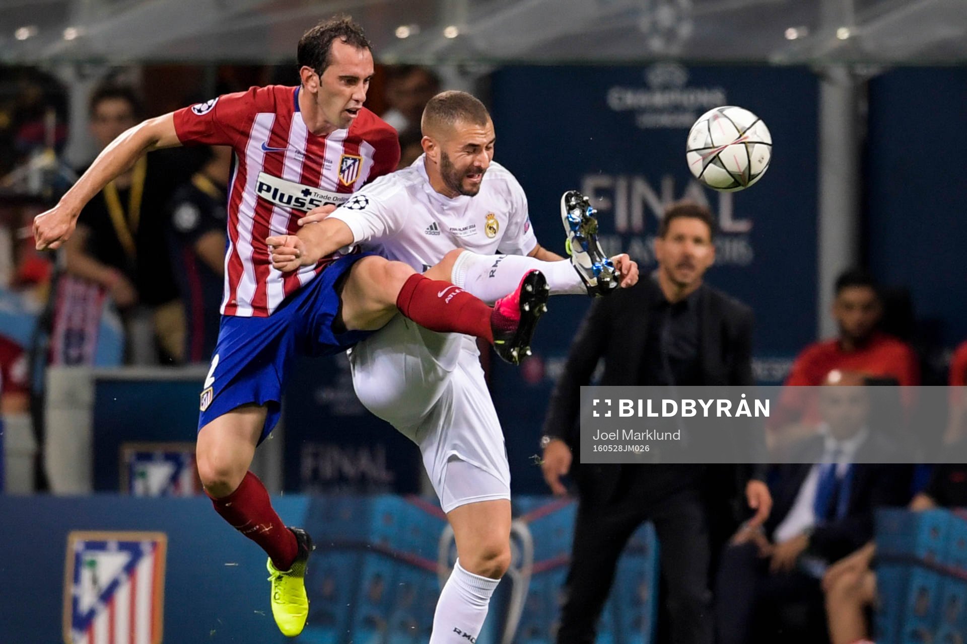 Atletico Madrids Diego Godin i kamp om bollen med Real