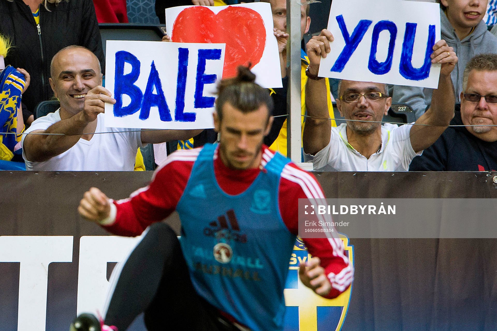 Två supportrar håller upp skyltar bakom Wales Gareth Bale