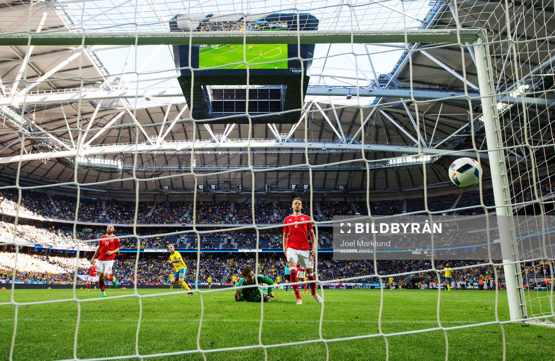 Sveriges John Guidetti skjuter in 3-0 bakom Wales målvakt