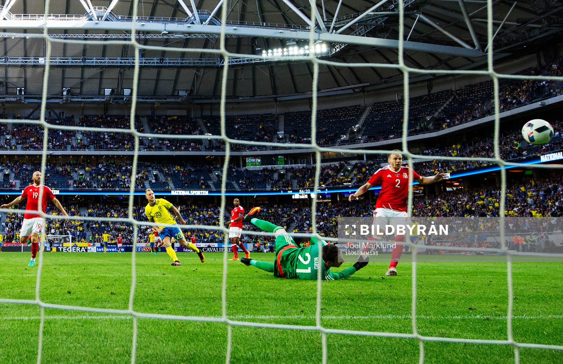 Sveriges John Guidetti skjuter in 3-0 bakom Wales målvakt Daniel Ward under fotbollslandskampen mellan Sverige och Wales den 5 juni 2016 i Stockholm.