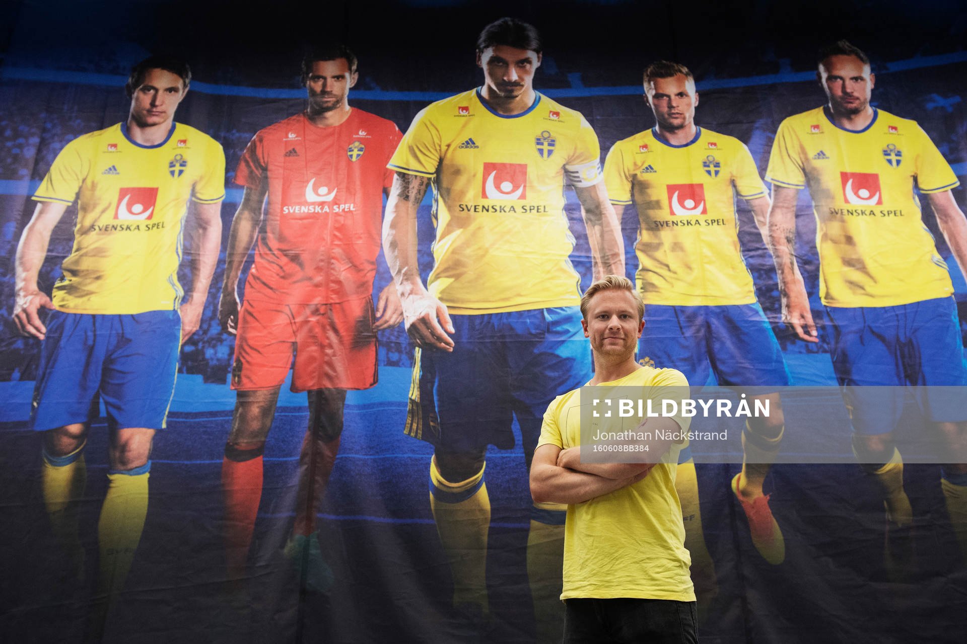 Bildbyråns fotograf Joel Marklund poserar framför en bild - som är tagen av honom - med porträtt på Kim Källström, Andreas Isaksson, Zlatan Ibrahimovic, Sebastian Larsson och Andreas Granqvist i presscentret inför Sveriges fotbollslandslags träning inför fotbolls-EM den 8 juni 2016 i Pornichet.