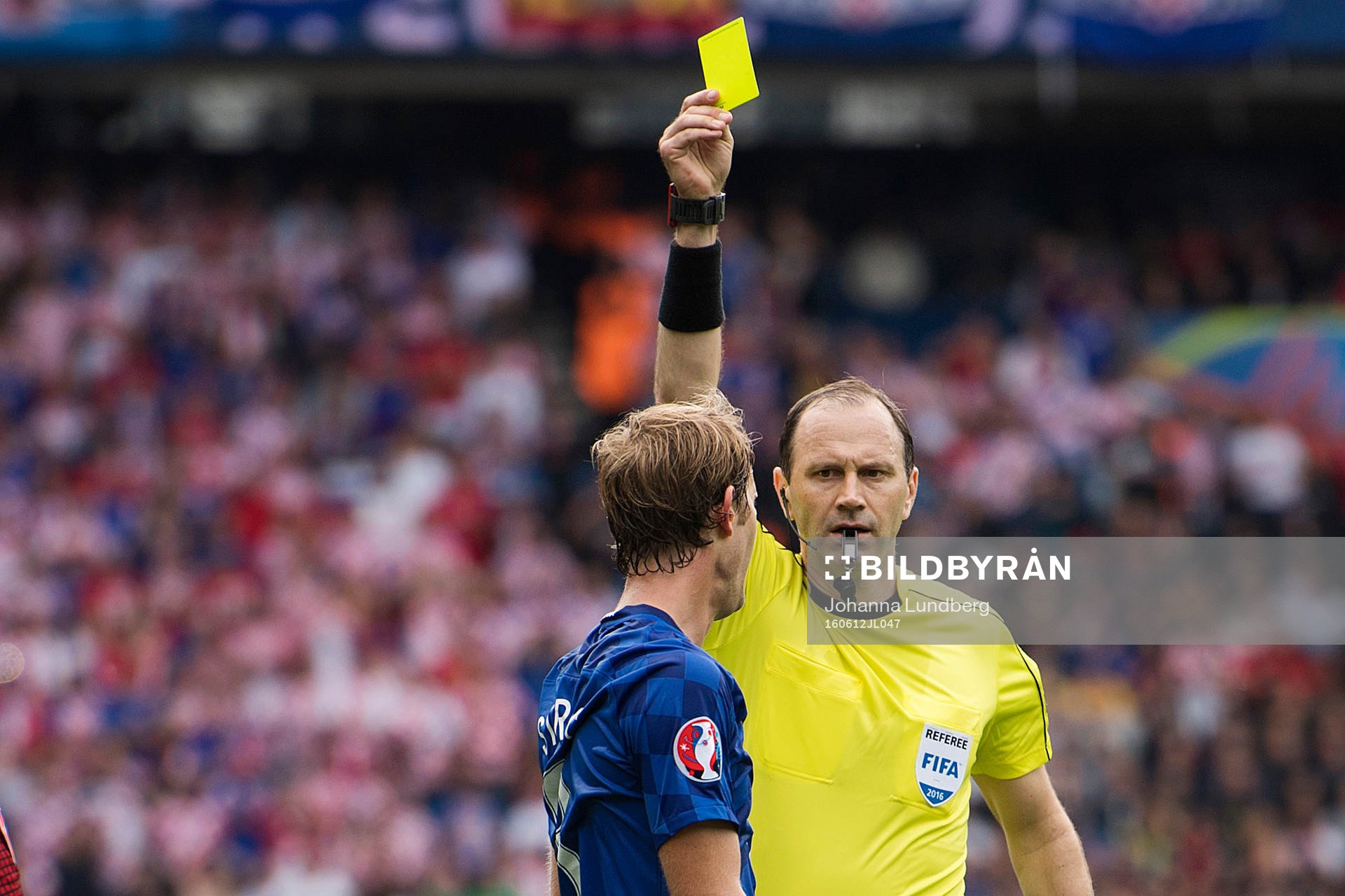 domare Jonas Eriksson delar ut ett gult kort