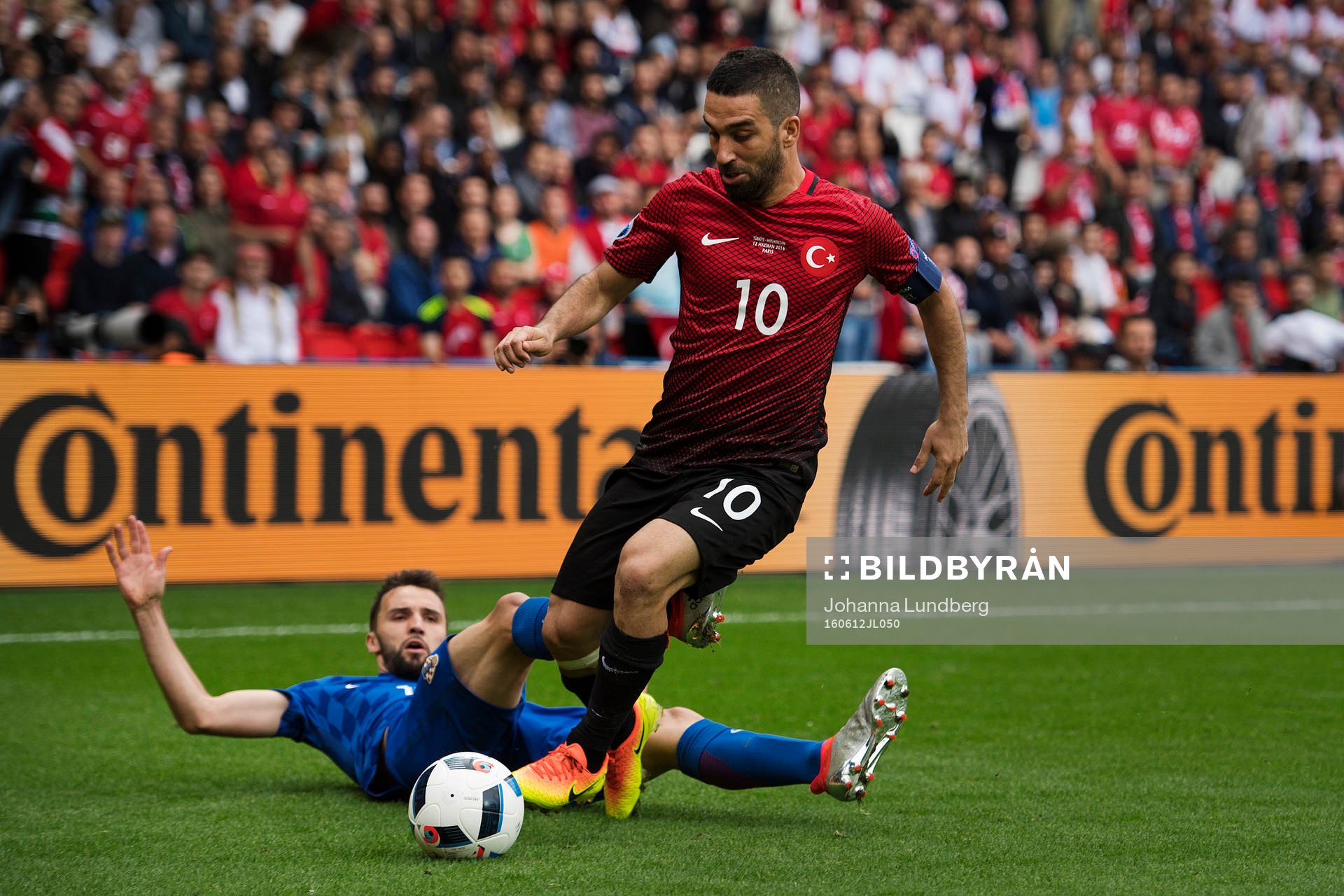 Turkiets Arda Turan hoppar över Kroatiens Milan Badelj under fotbollsmatchen mellan Turkiet och Kroatien under Fotbolls-EM den 12 juni 2016 i Paris.