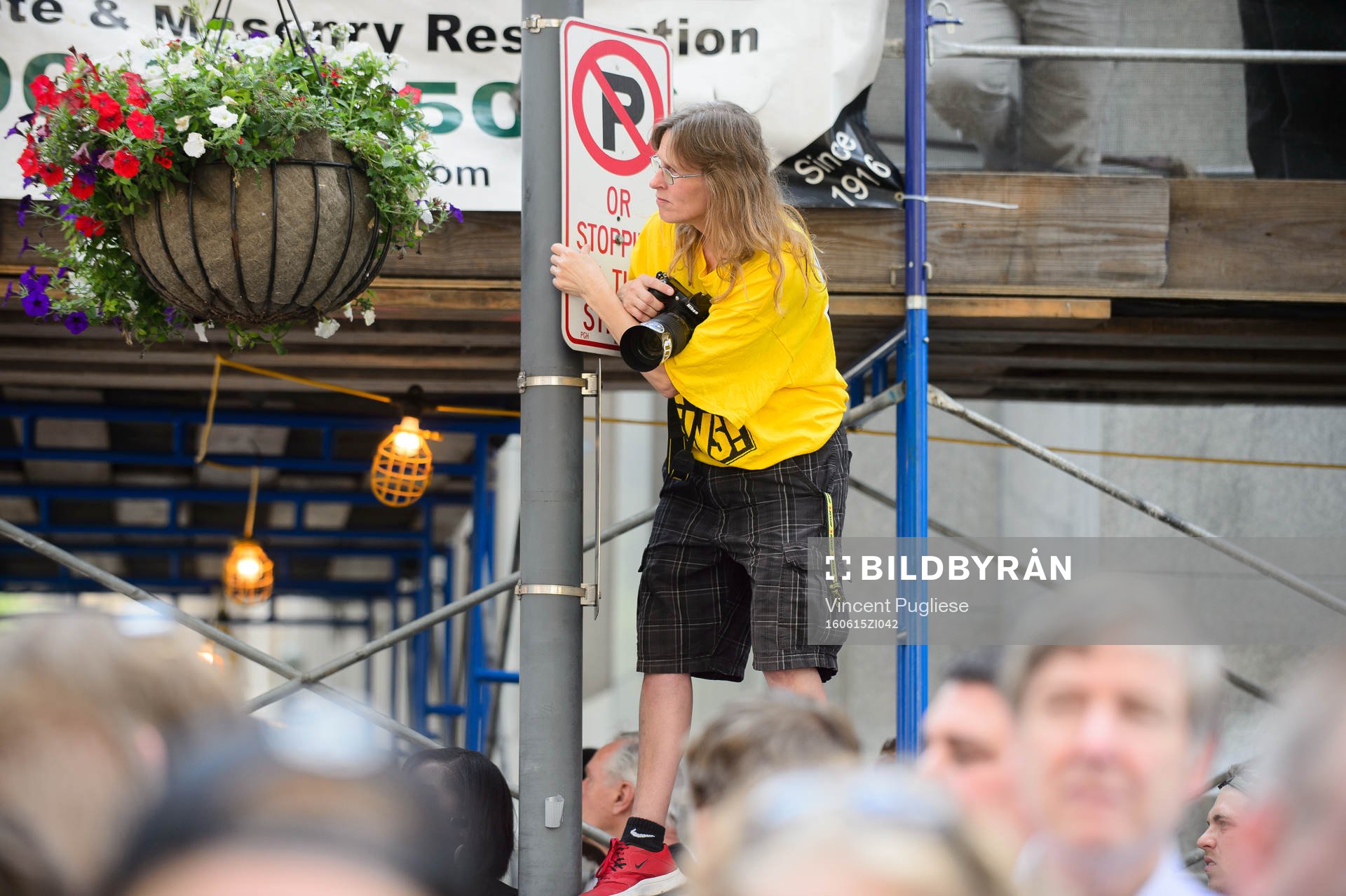 A Pittsburgh Penguins fan hangs from a street sign to try