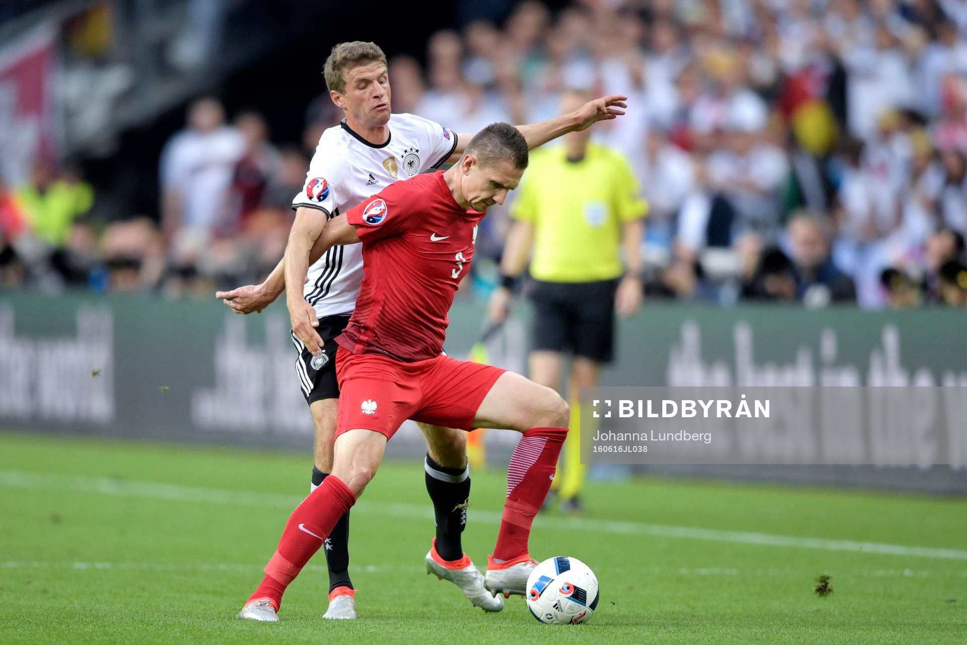 Tysklands Thomas Muller i närkamp med Polens Artur Jedrzejczyk i fotbollsmatchen mellan Tyskland och Polen under fotbolls-EM den 16 juni 2016 i Saint-Denis.