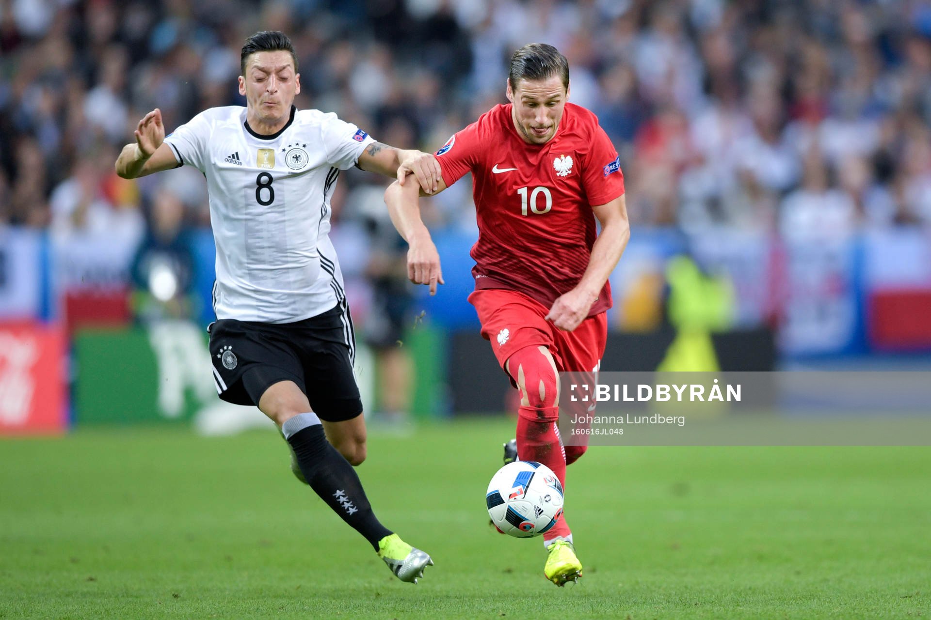 Tysklands Mesut Özil jagar Polens Grzegorz Krychowiak i
