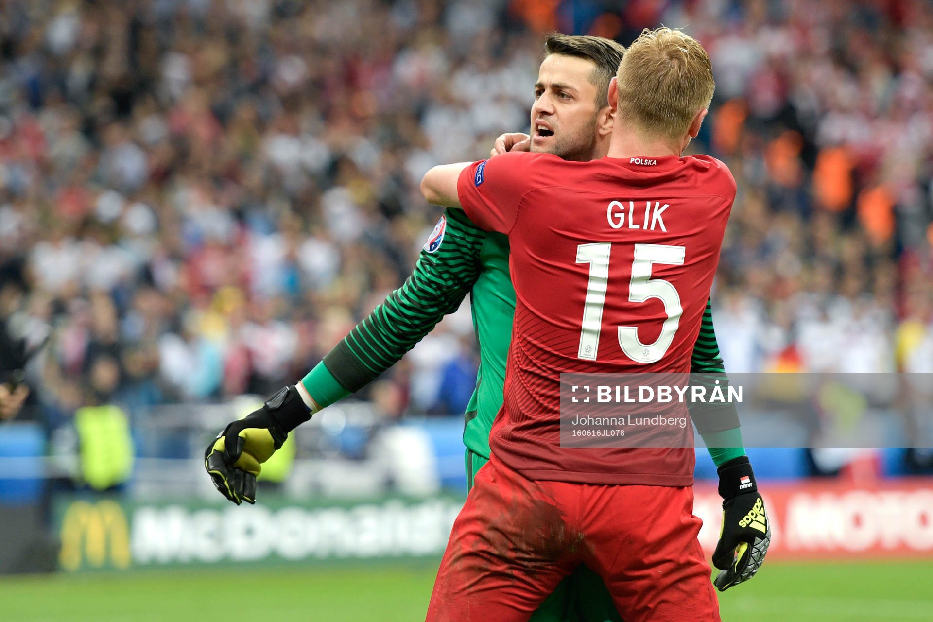 Polens målvakt Lukasz Fabianski kramas om av Kamil Glik efter fotbollsmatchen mellan Tyskland och Polen under fotbolls-EM den 16 juni 2016 i Saint-Denis.