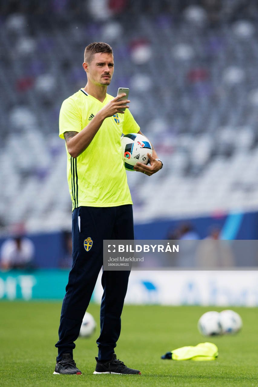 Mikael Lustig tar bilder med en mobiltelefon när han är