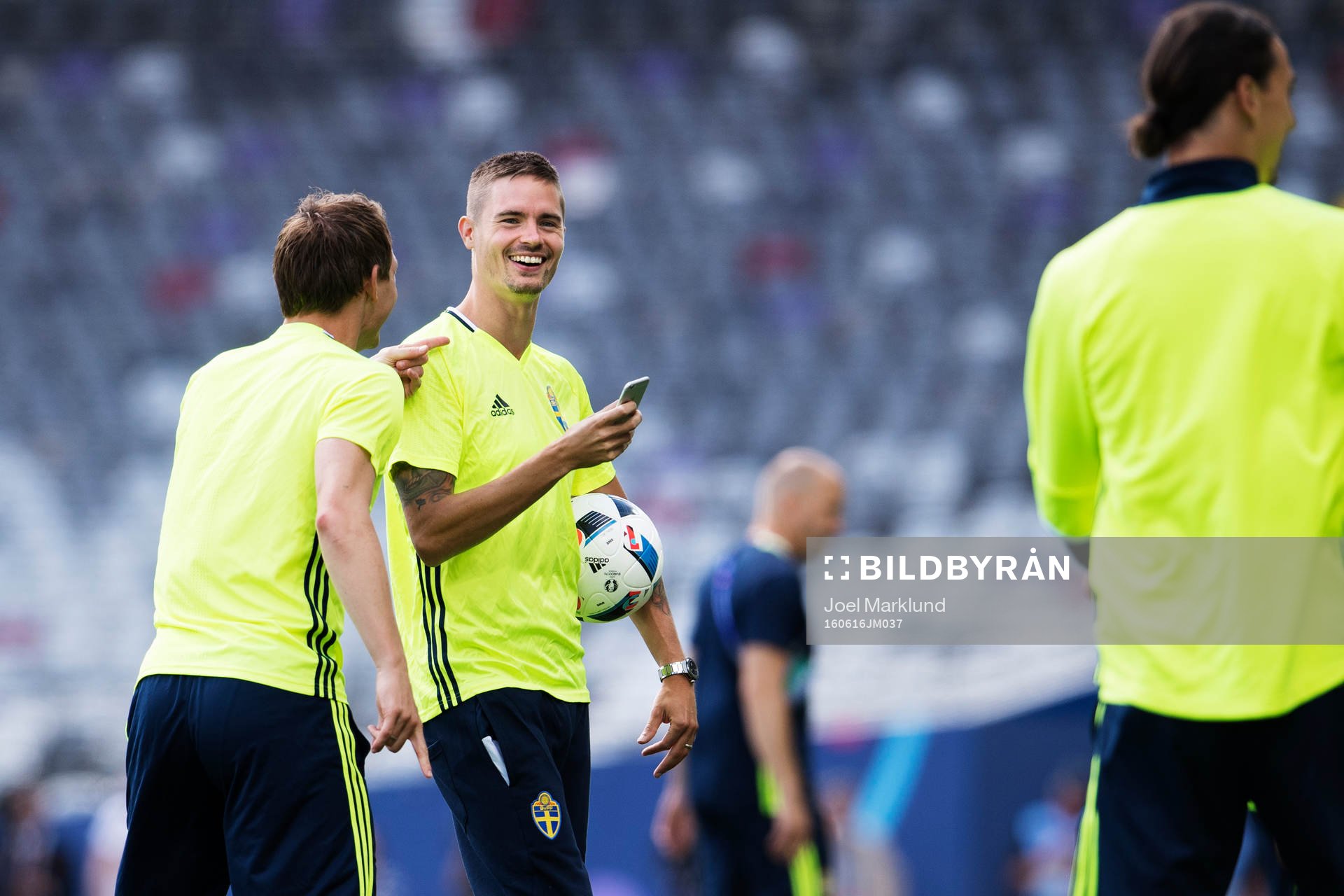Mikael Lustig tar bilder med en mobiltelefon när han är