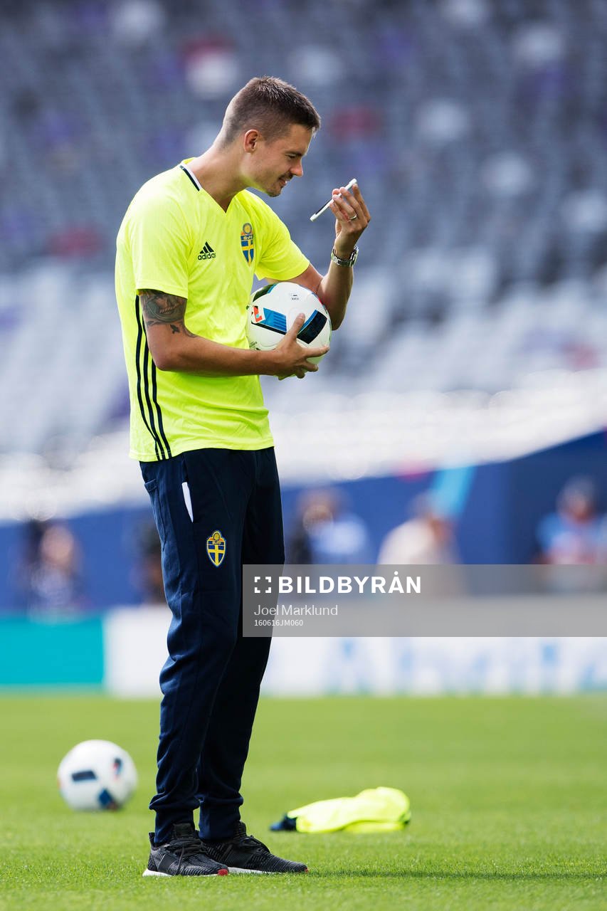 Mikael Lustig tittar på en mobiltelefon när han är med