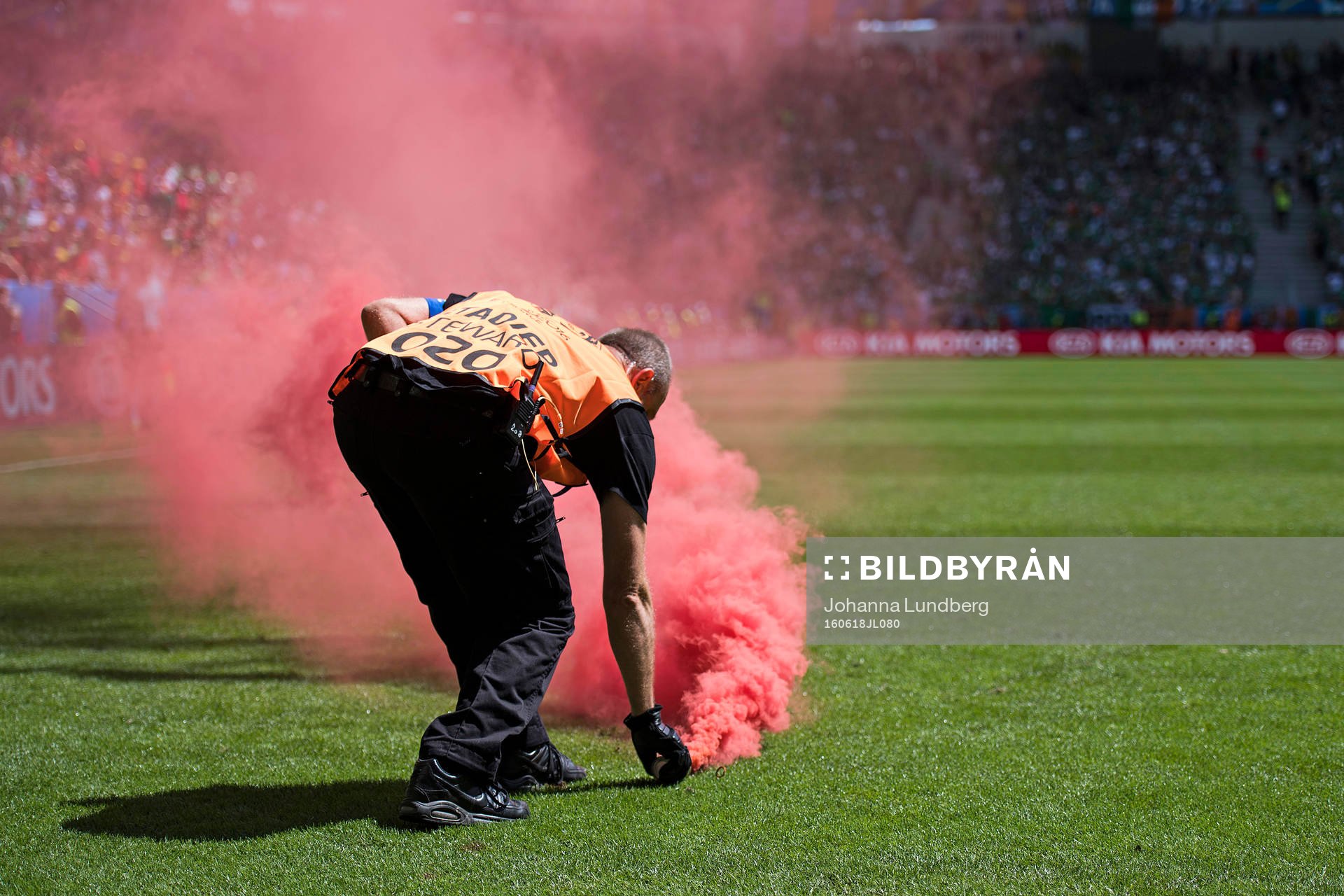 En publikvärd gör sig av med en rökbengal i