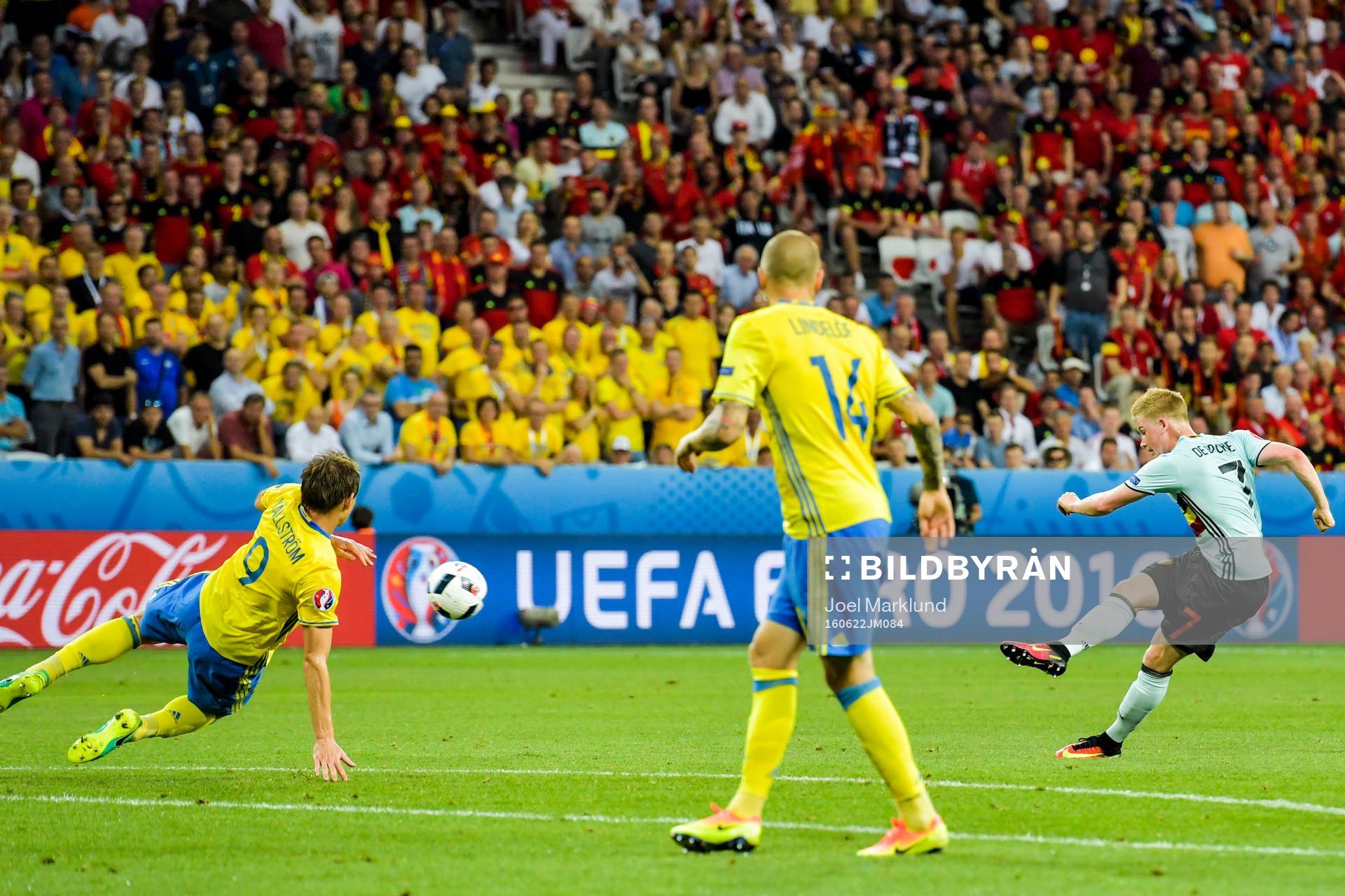 Belgiens Kevin de Bruyne skjuter och Sveriges Kim Källström kastar sig för att täcka skott i fotbollsmatchen mellan Sverige och Belgien under fotbolls-EM den 22 juni 2016 i Nice.