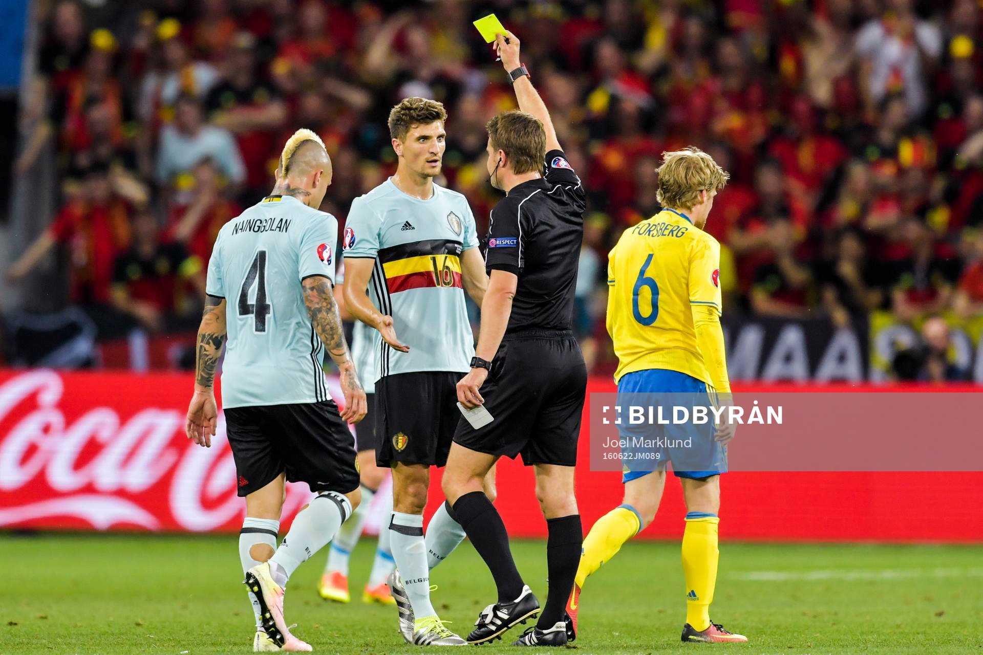 Belgiens Thomas Meunier får gult kort av domare Felix