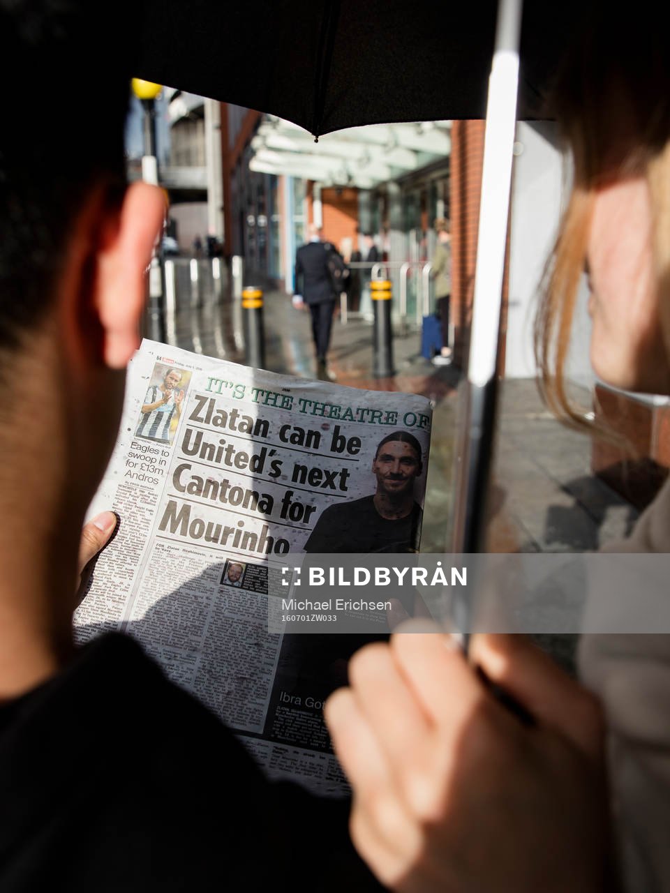 Ett par som läser ett engelskt tidningsuppslag med Zlatan