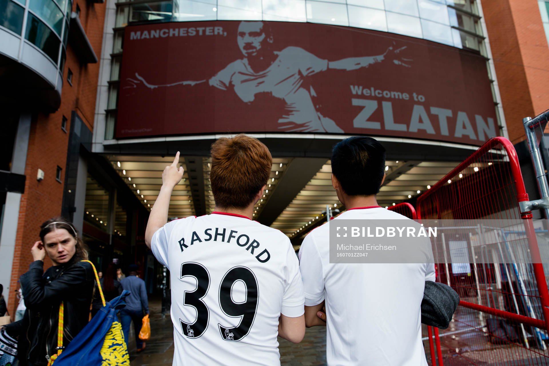 Två united supportrar kollar in en stor skärm med Zlatan