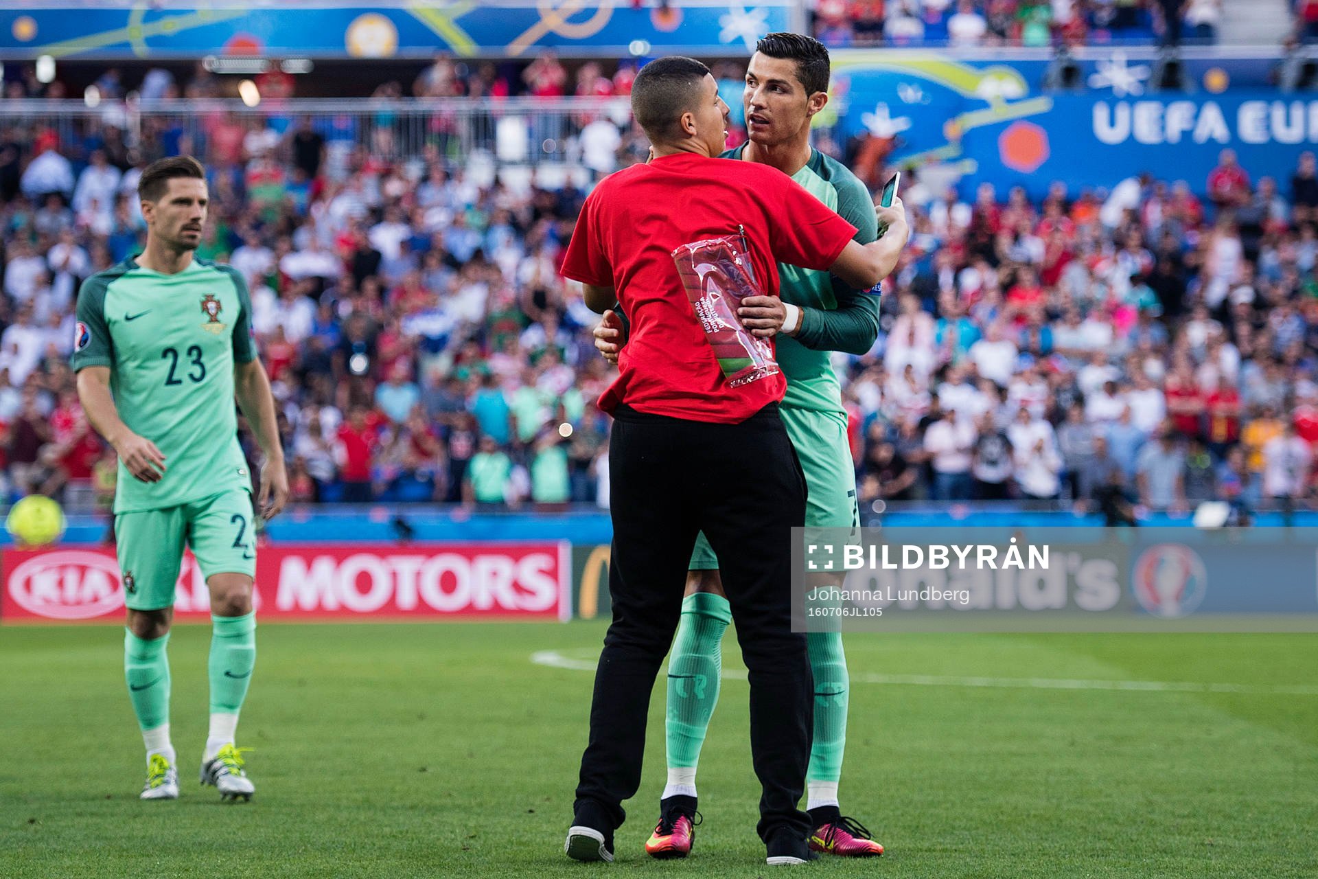 En person tar sig in och kramar Portugals Cristiano Ronaldo