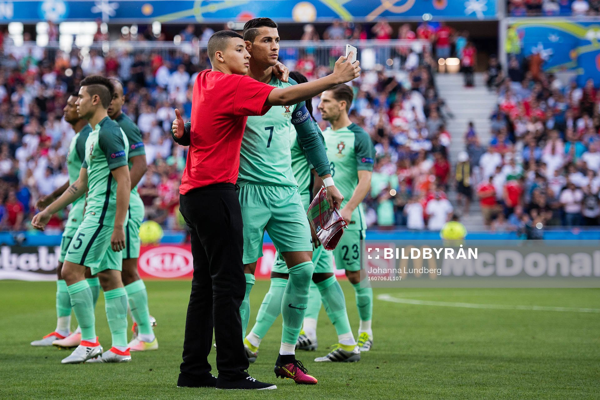 En person tar sig in och tar en selfie med Portugals Cristiano Ronaldo under fotbollsmatchen mellan Portugal och Wales under fotbolls-EM den 6 juli 2016 i Lyon.