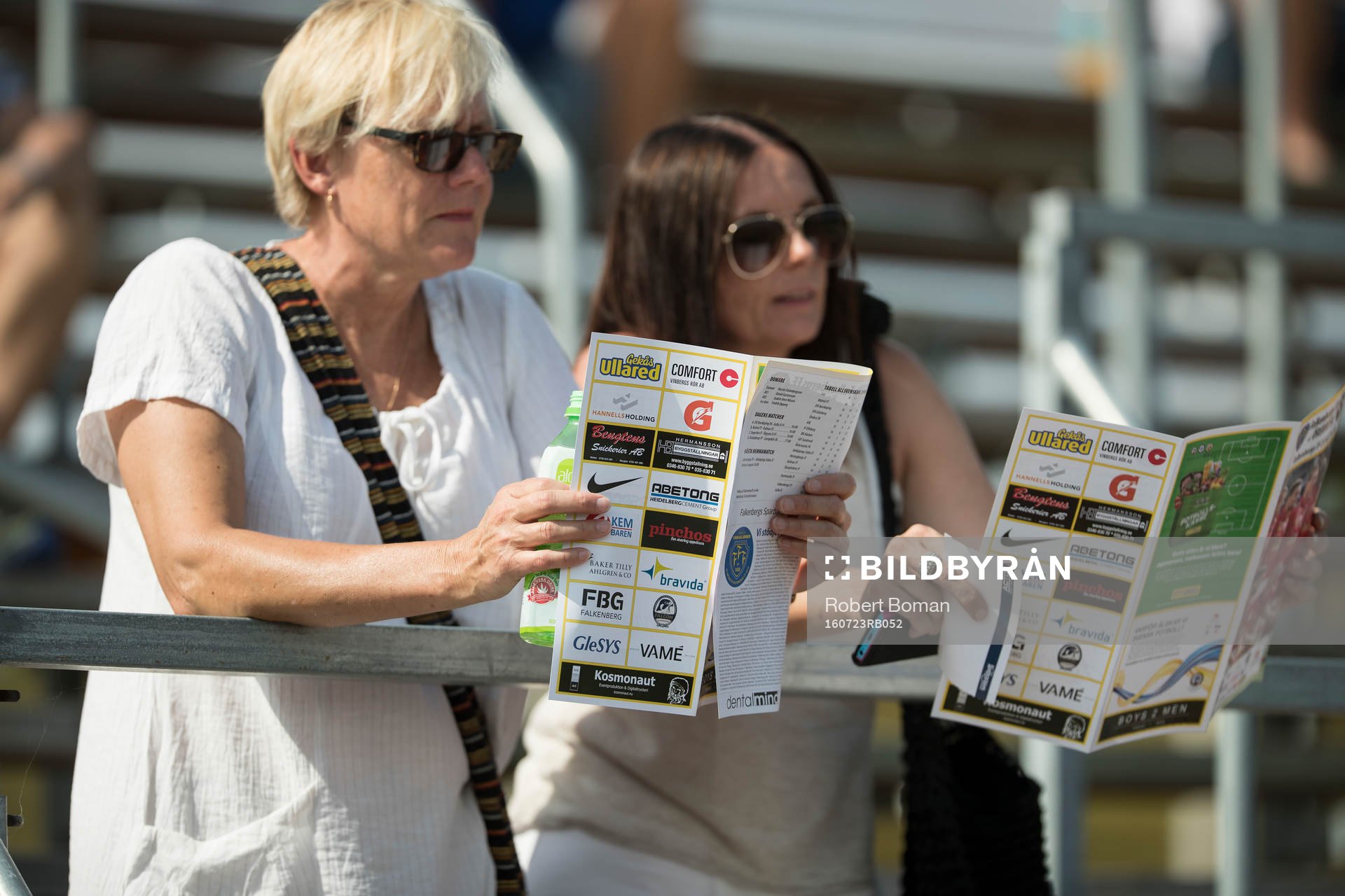 Två supportrar läser programblad