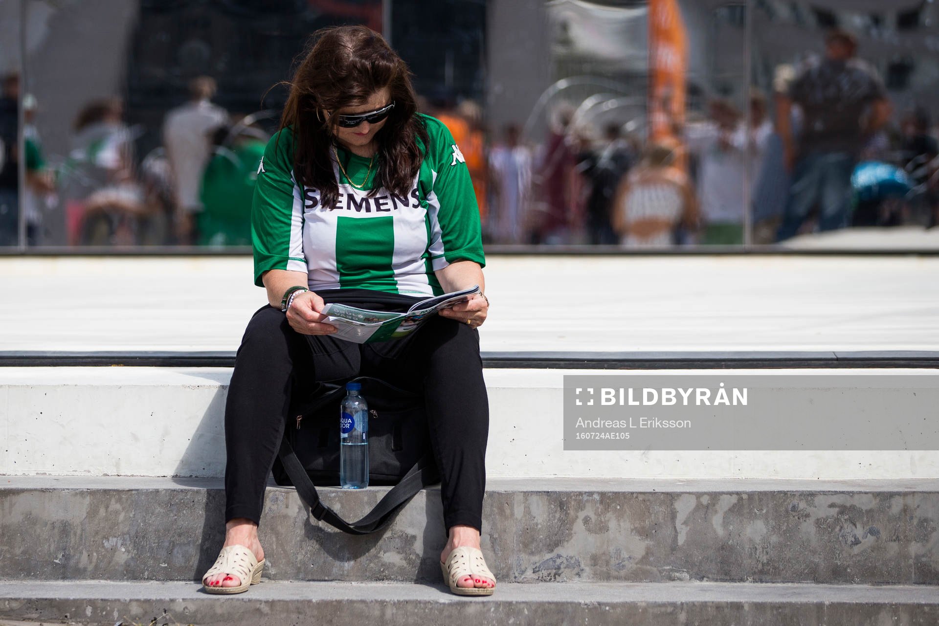 En supporter till Hammarby sitter och läser