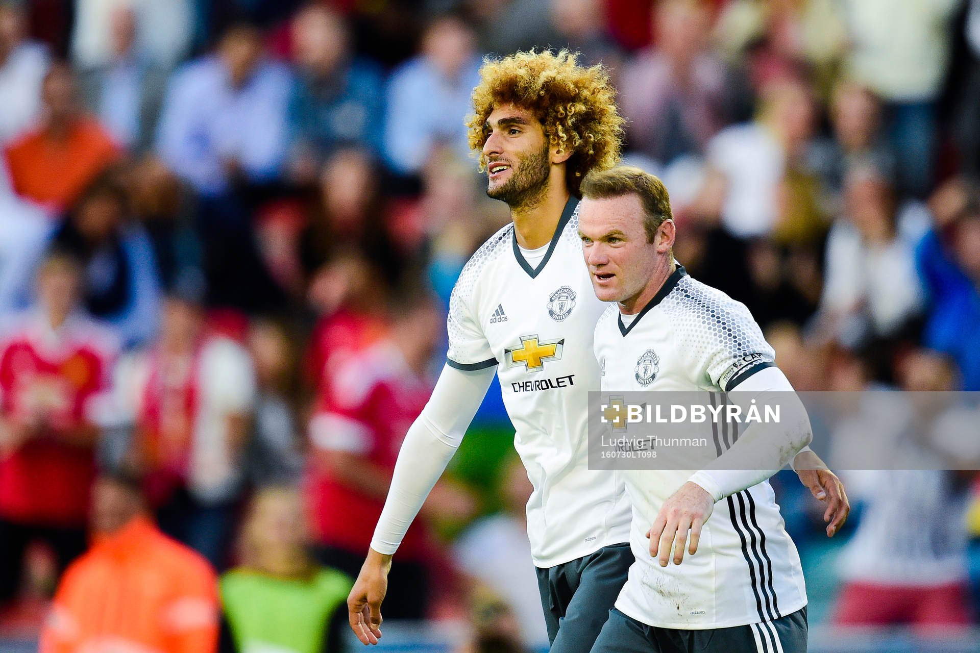 Manchester Uniteds Wayne Rooney och Marouane Fellaini jublar