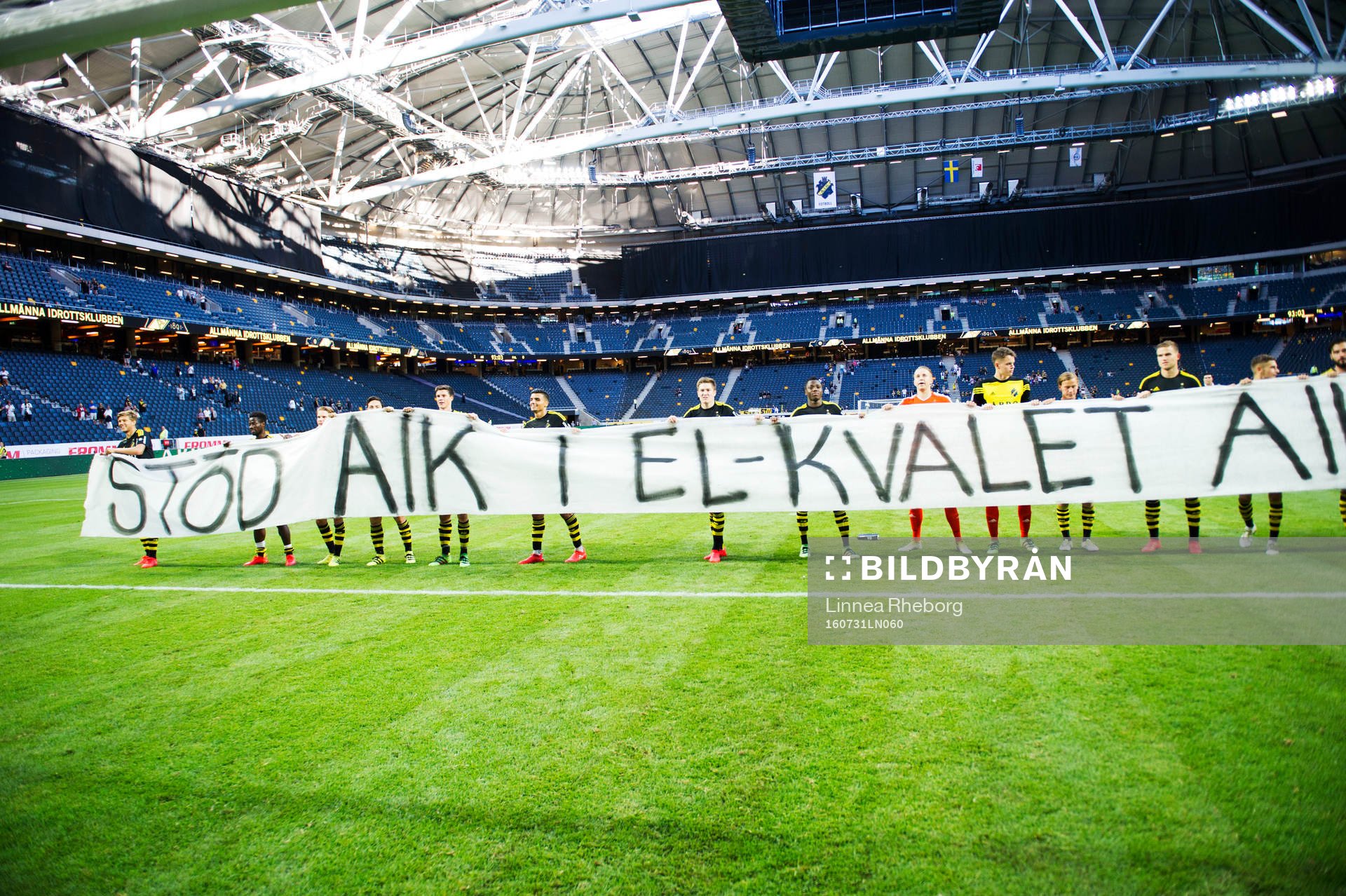 s spelare rullar ut en banderoll som säger stöd AIK i