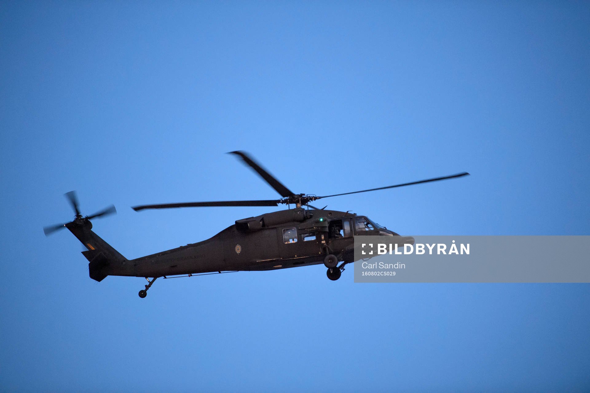 En militärhelikopter flyger över planen på en träning