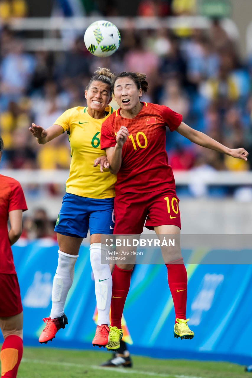 Brasiliens Tamires och Kinas Li Yang i fotbollsmatchen