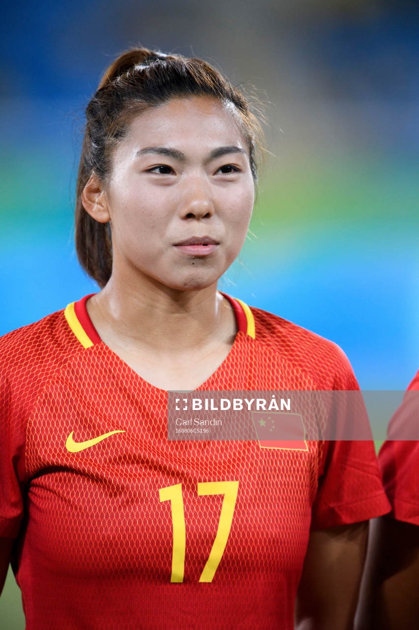 Kinas Yasha Gu vid lineup innan fotbollsmatchen mellan