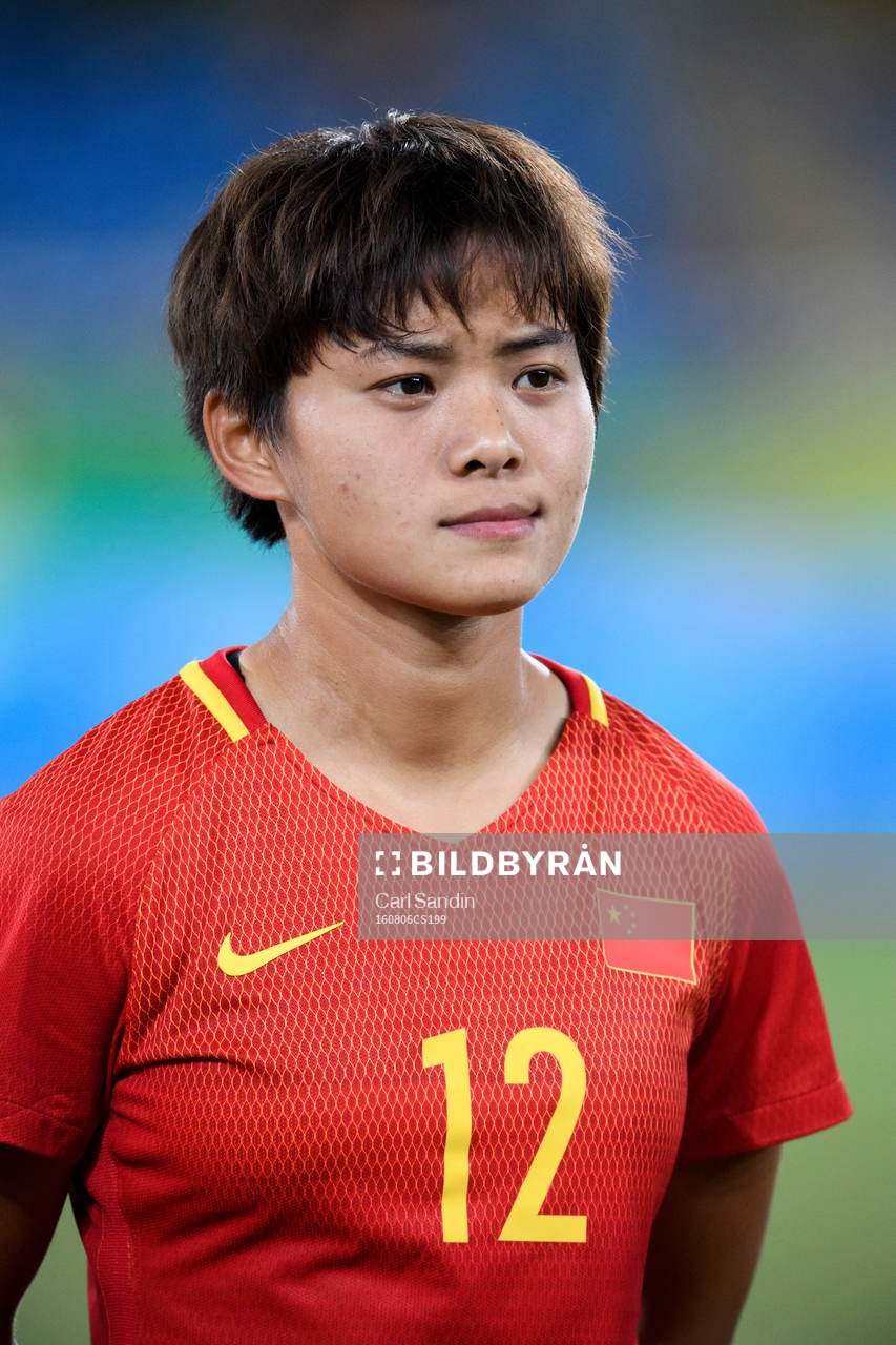 Kinas Shuang Wang vid lineup innan fotbollsmatchen mellan
