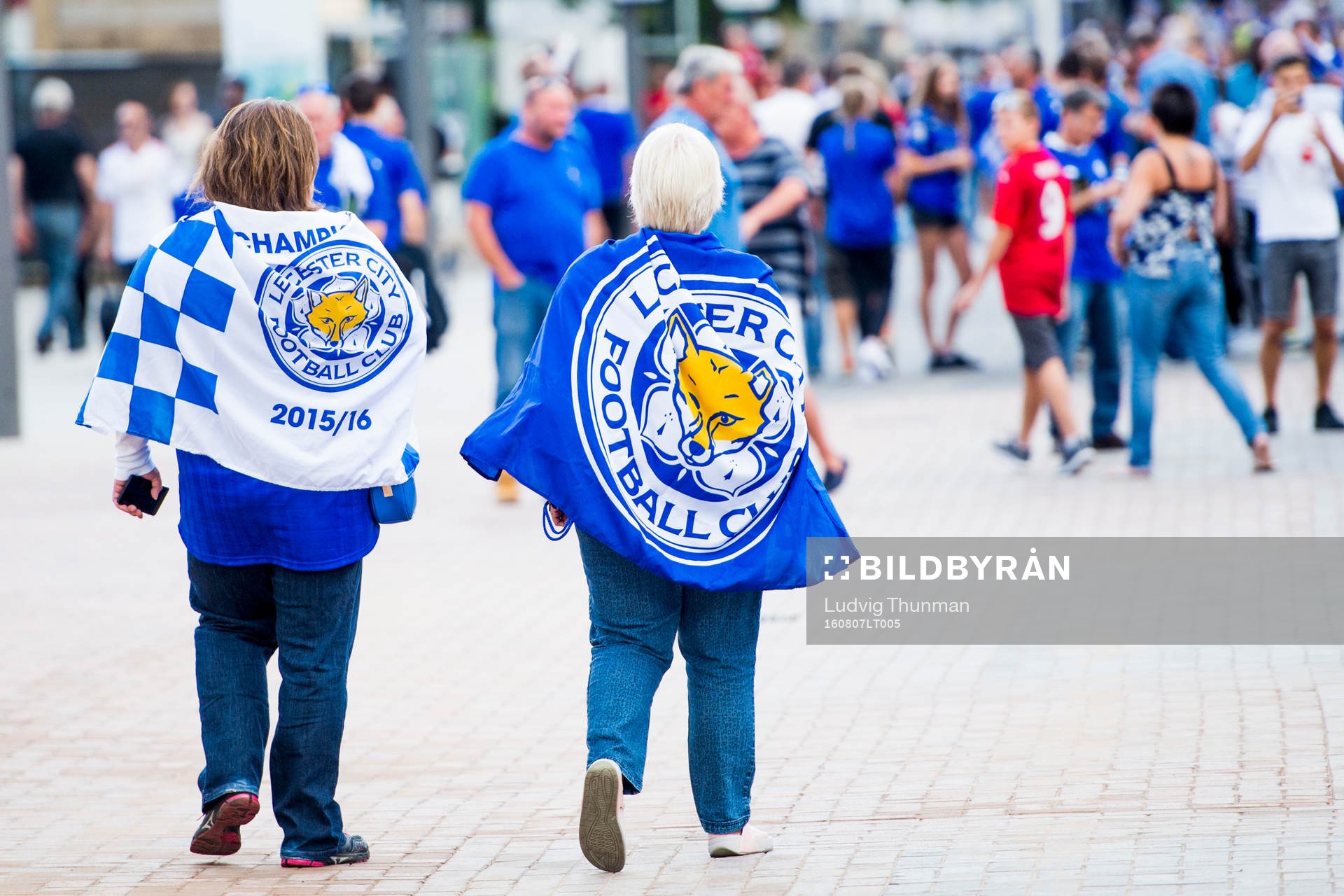 Två Leicester City supportrar med klubbens flaggor på