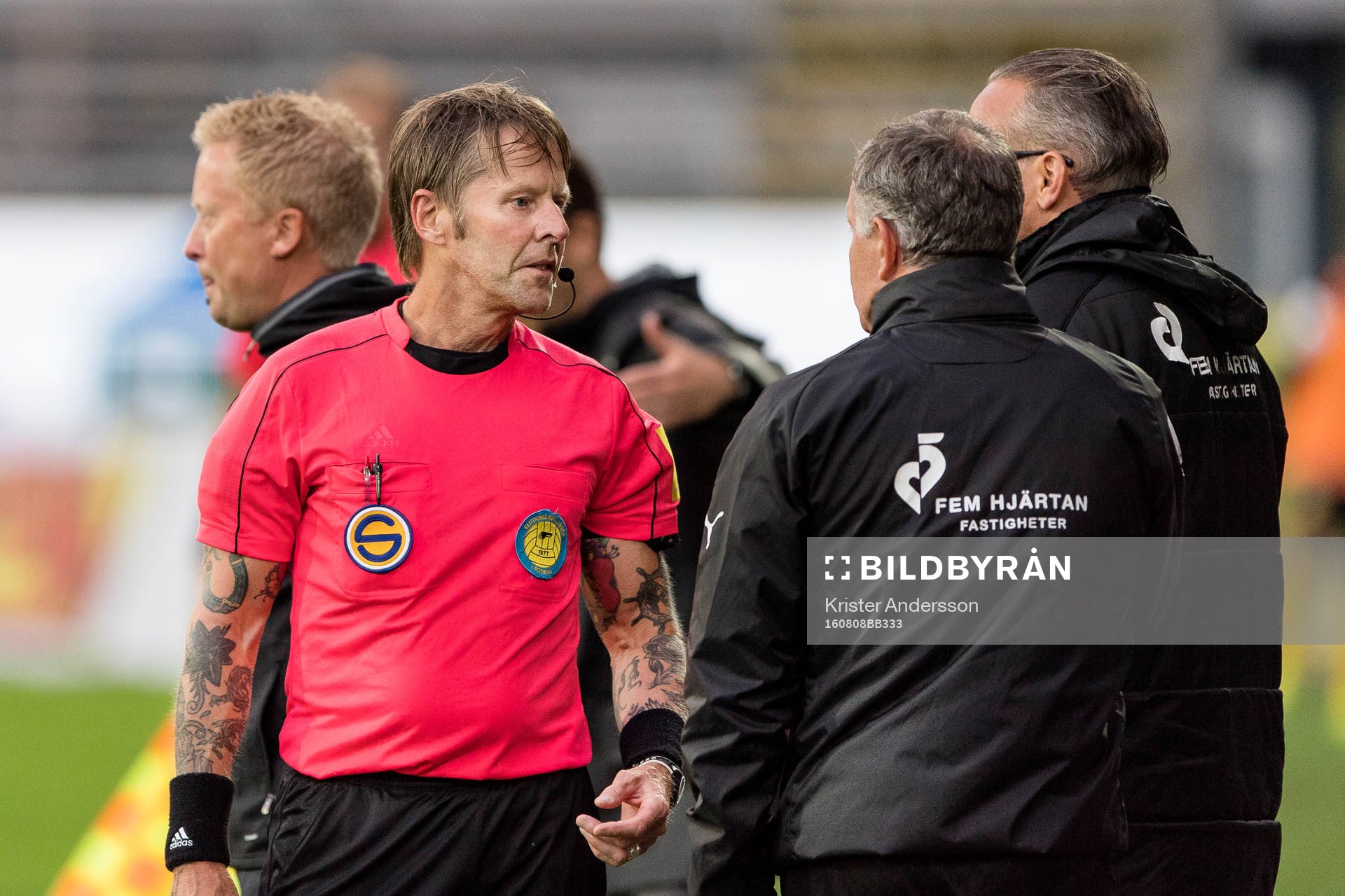 Domare Lars Olsson visar upp Halmstads tränare Jan