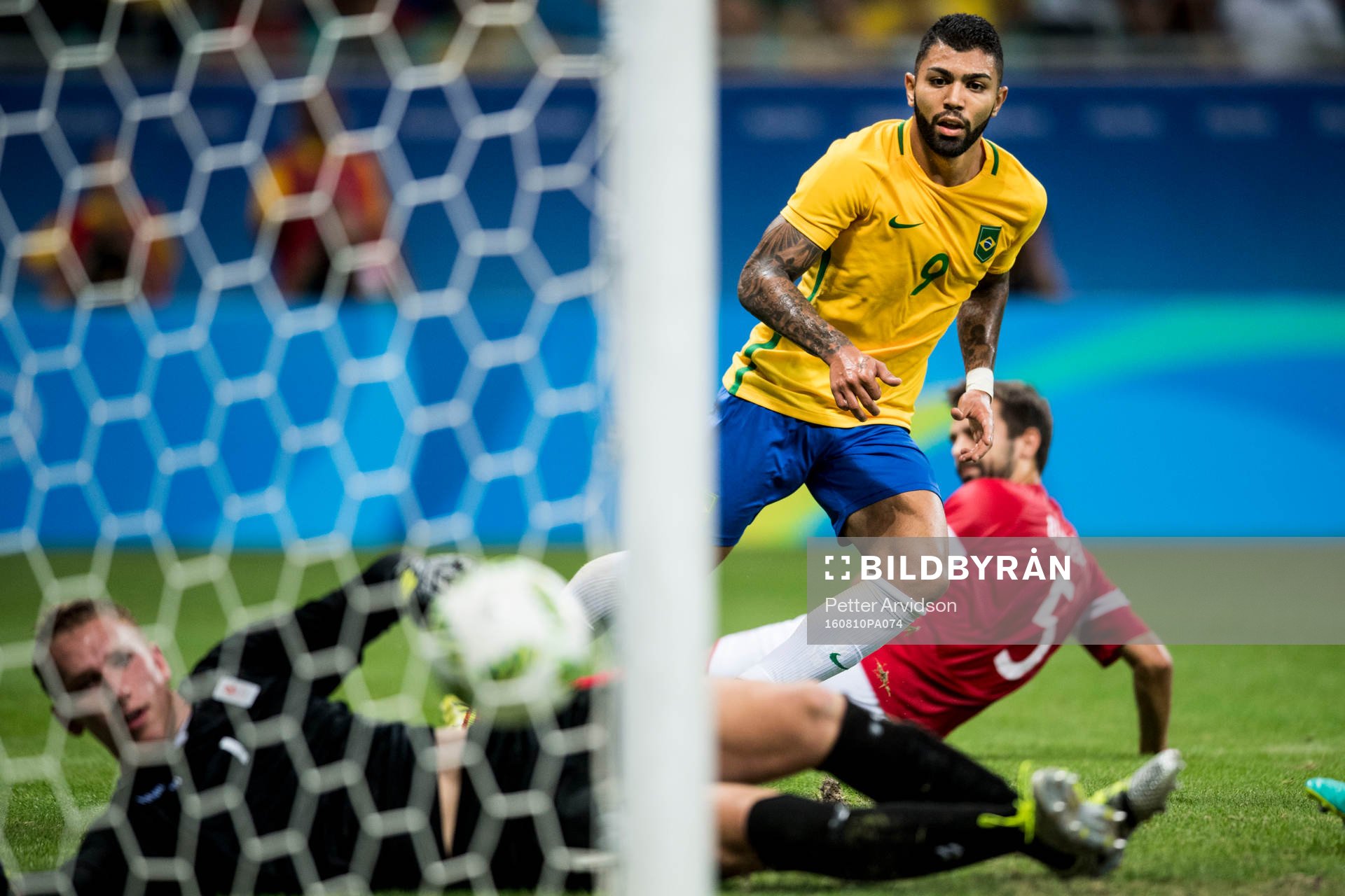 Brasiliens Gabriel Barbosa gör 1-0 bakom Danmarks målvakt Jeppe Højbjerg under fotbollsmatchen mellan Brasilien och Danmark den 10 augusti 2016 under OS i Salvador.
