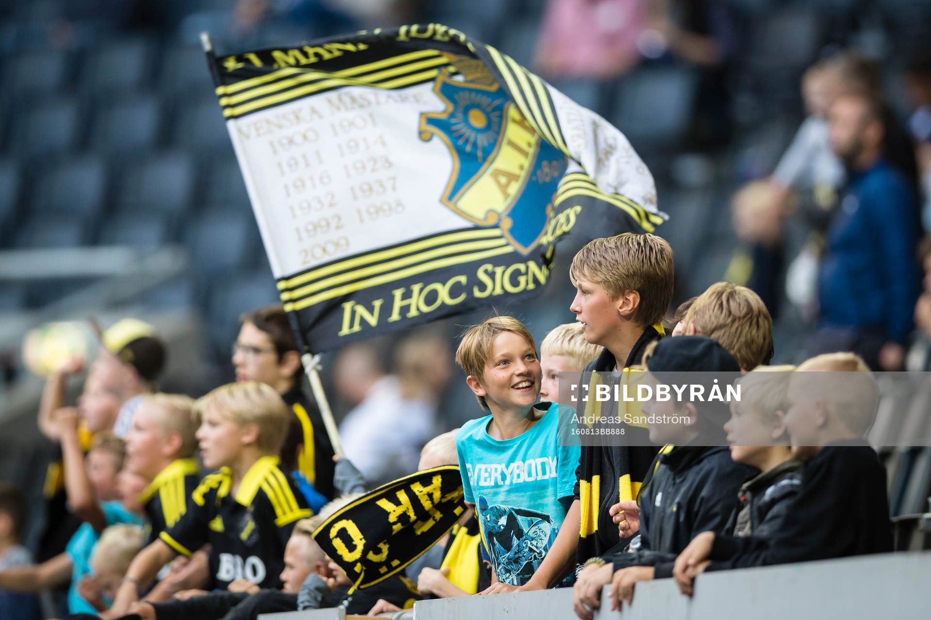 Unga AIK supportar viftar med halsdukar och flaggor
