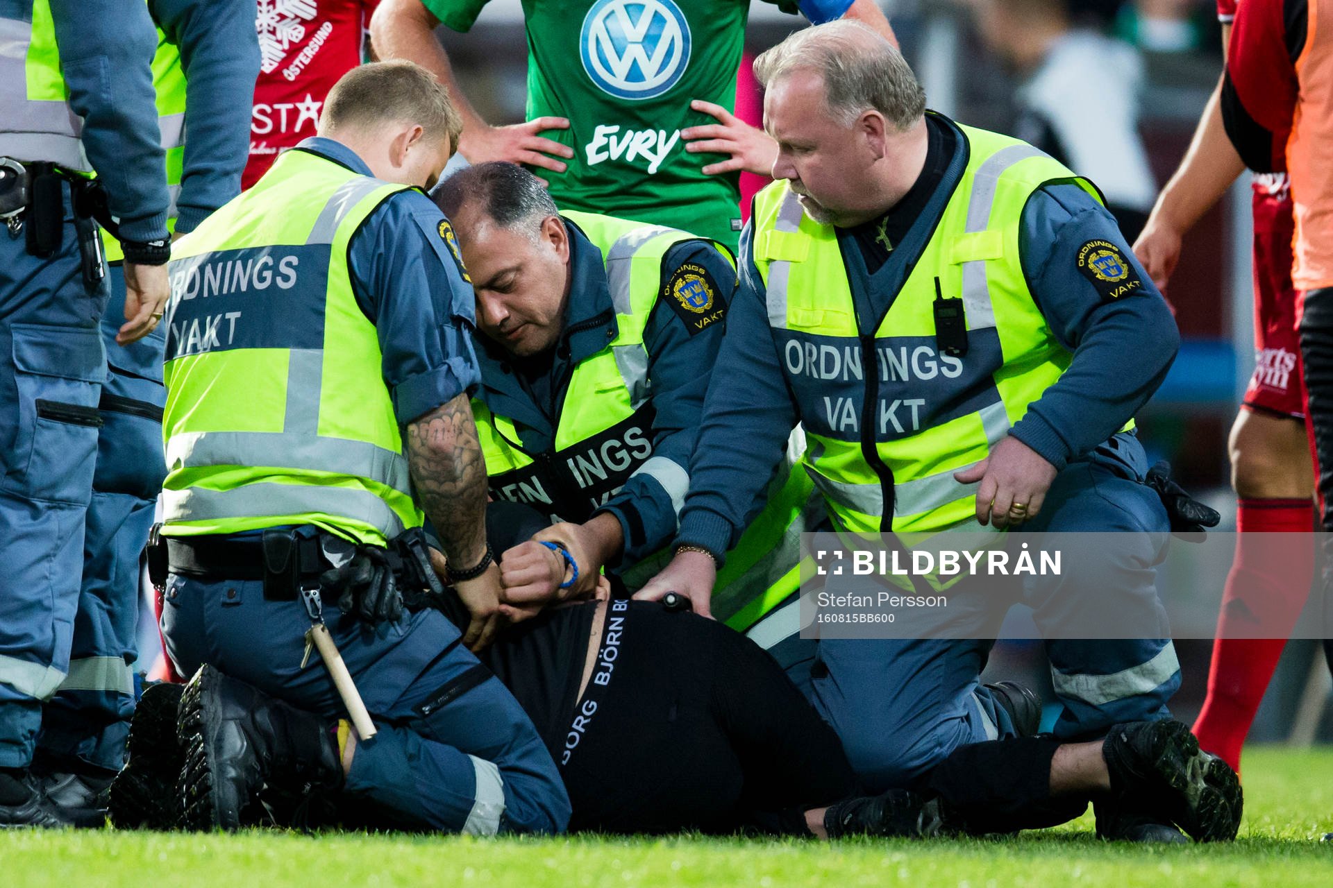 Ordningsvakter griper personen som sprang in på planen och