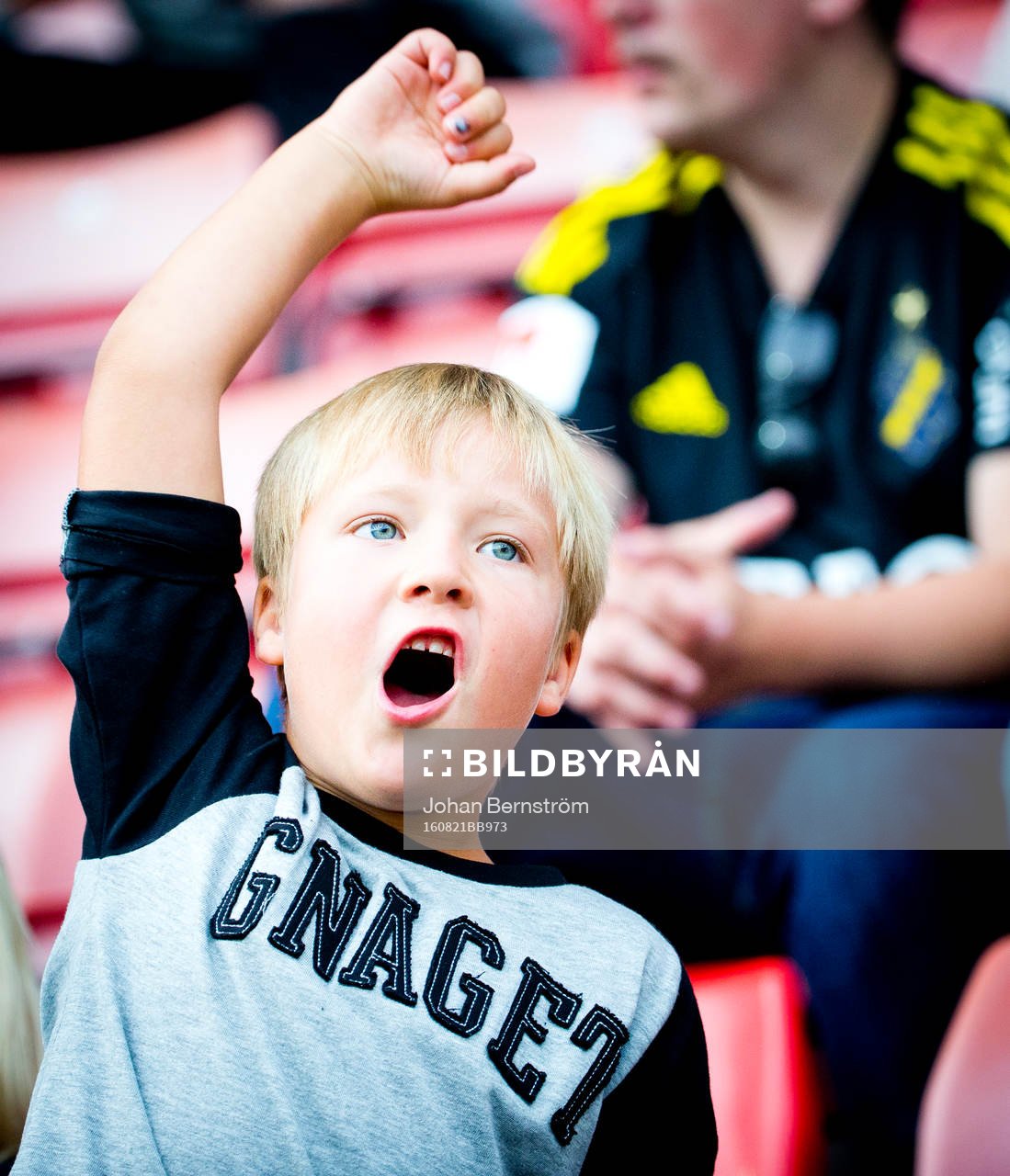 Ung AIK supporter med tröja med texten gnaget gestikulerar