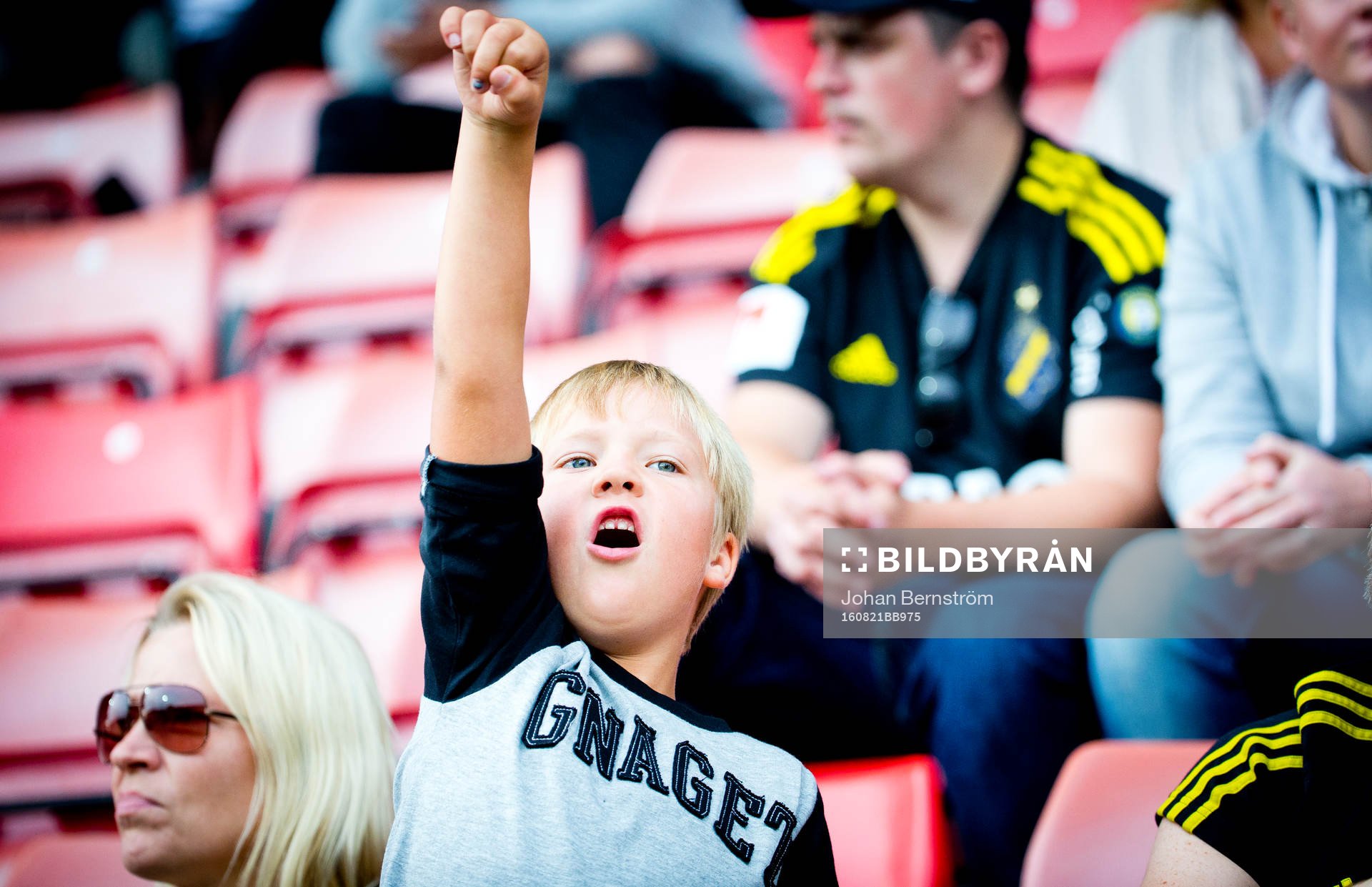 Ung AIK supporter med tröja med texten gnaget gestikulerar