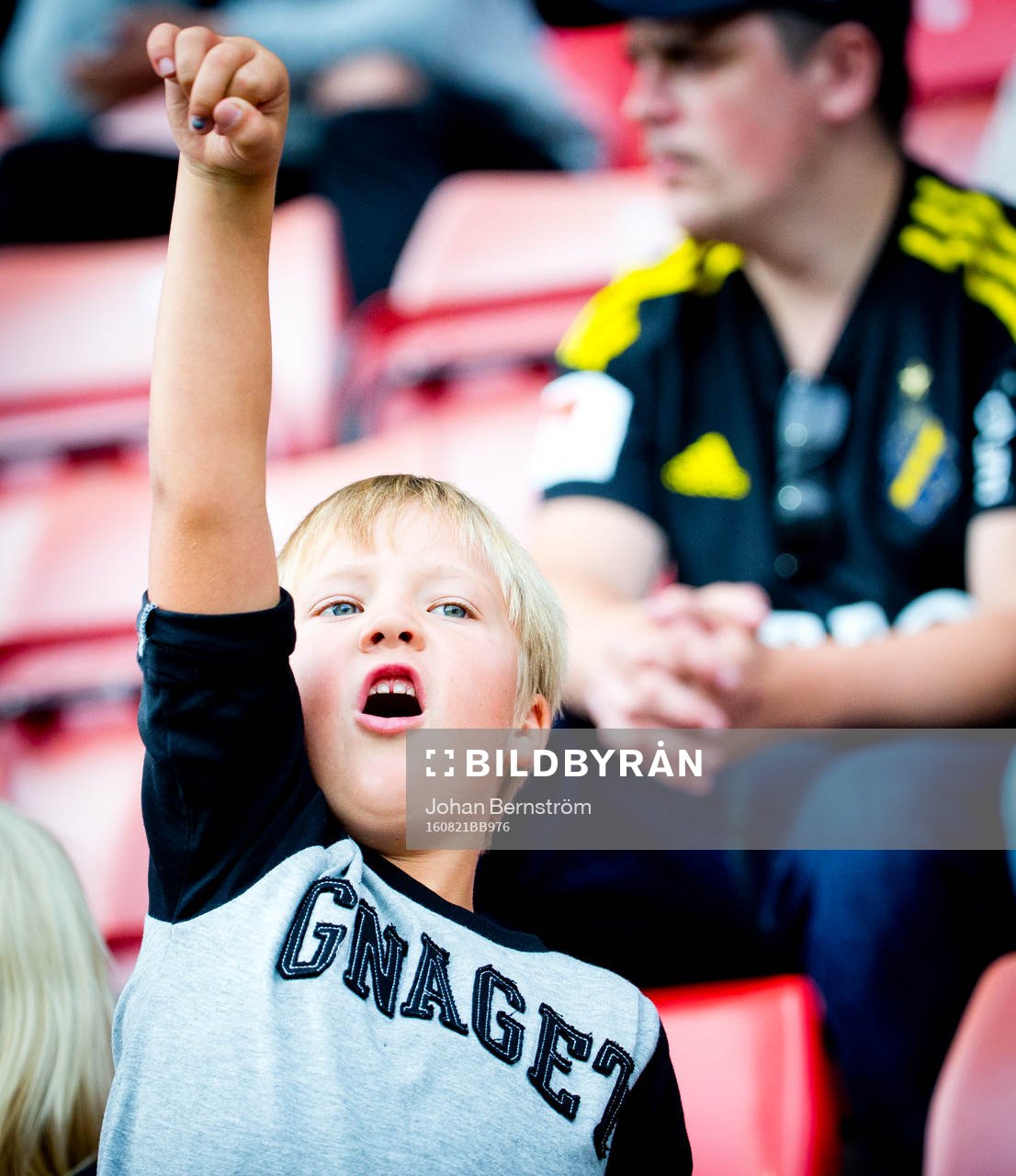 Ung AIK supporter med tröja med texten gnaget gestikulerar