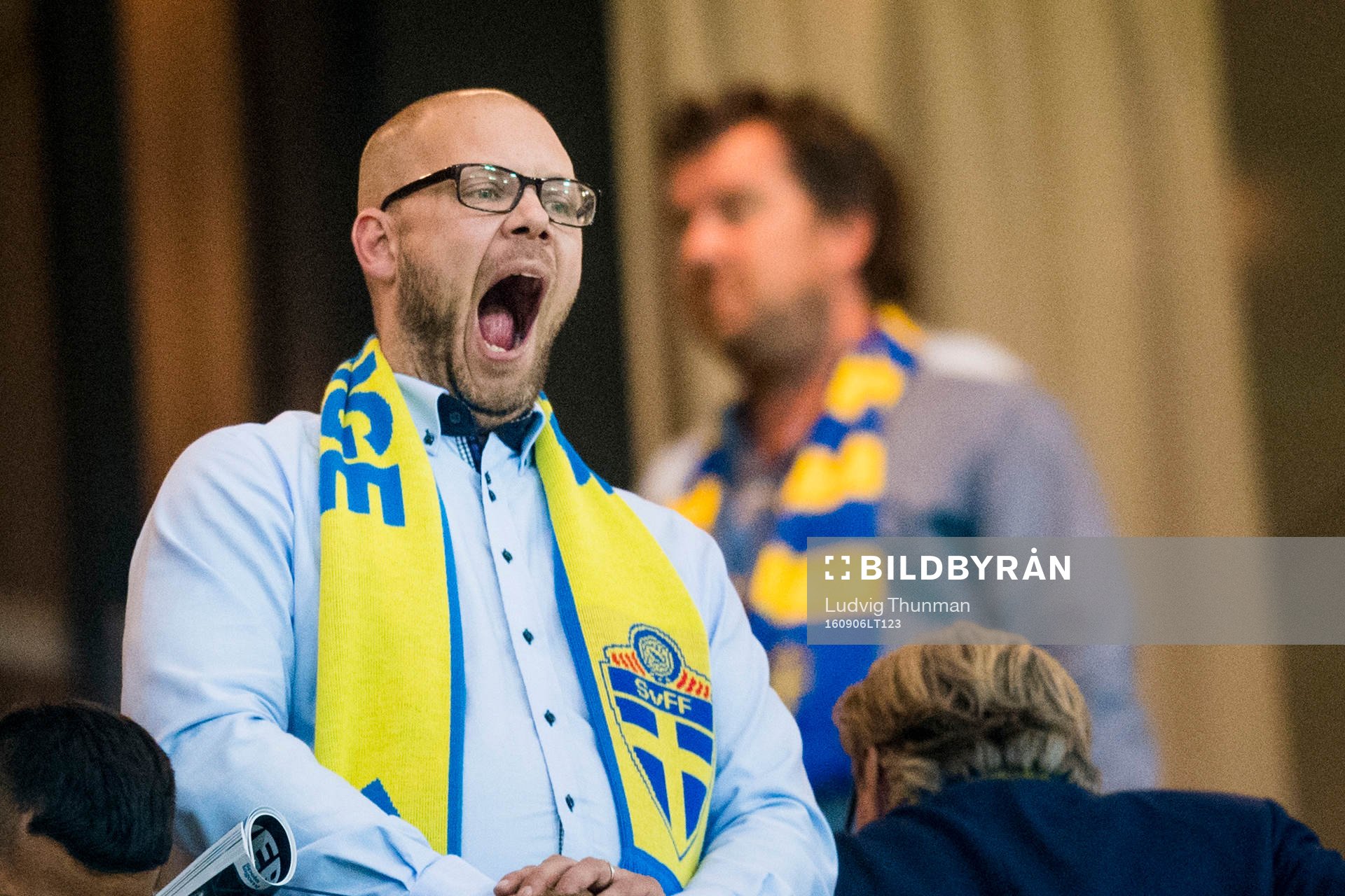 En svensk supporter med halsduk gäspar