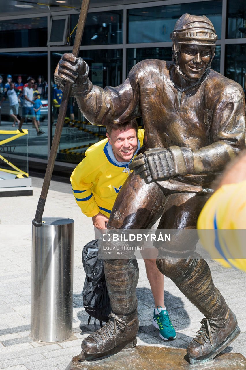 En svensk supporter bli fotograferad vid en staty av Mats