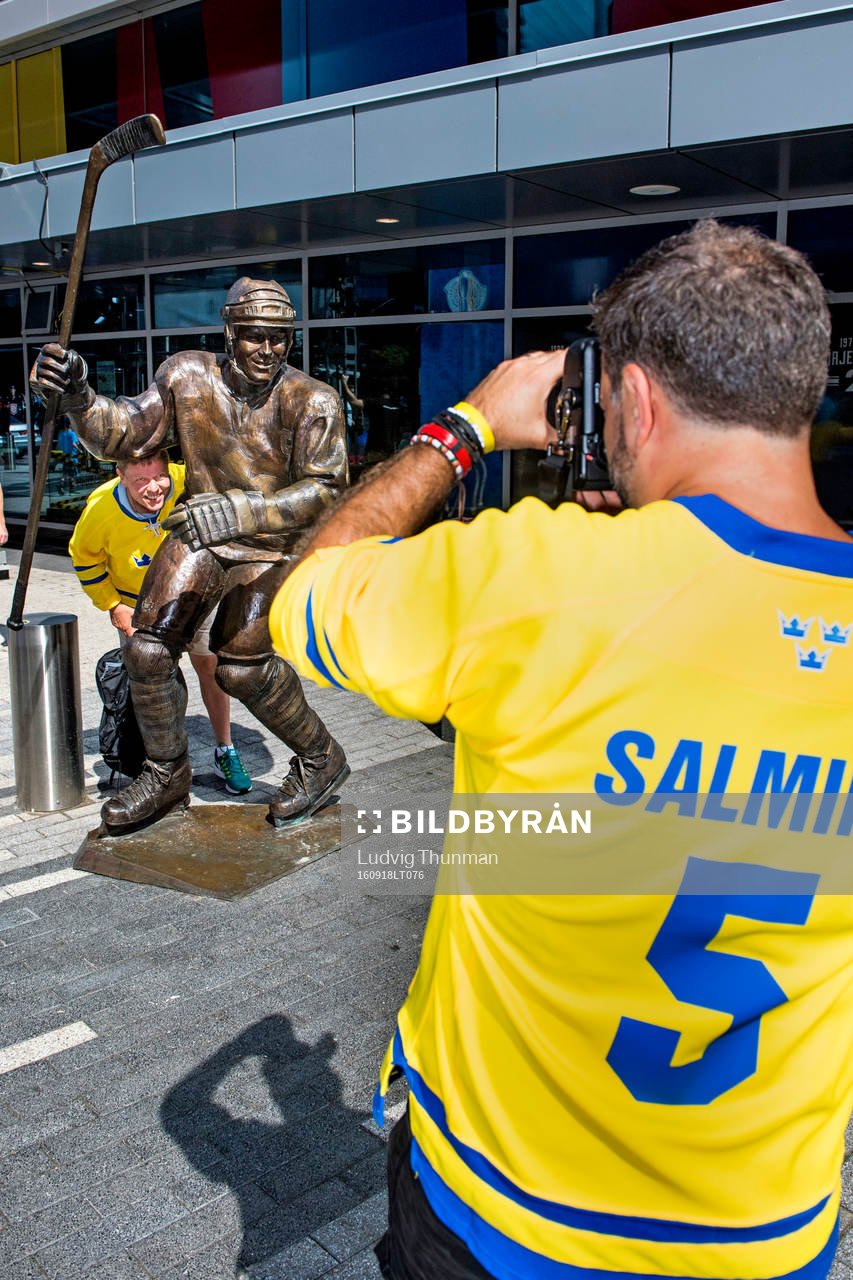 En svensk supporter bli fotograferad vid en staty av Mats