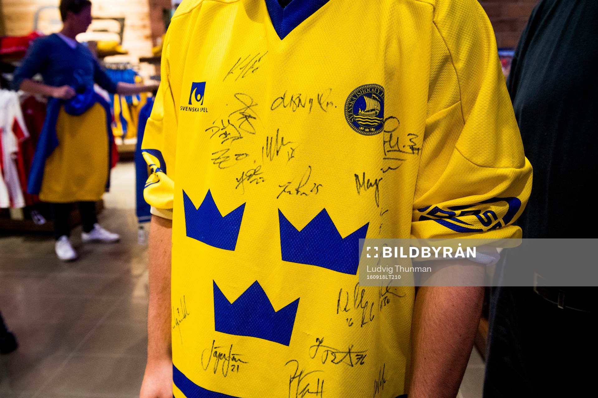 En person bär en svensk matchtröja med autografer