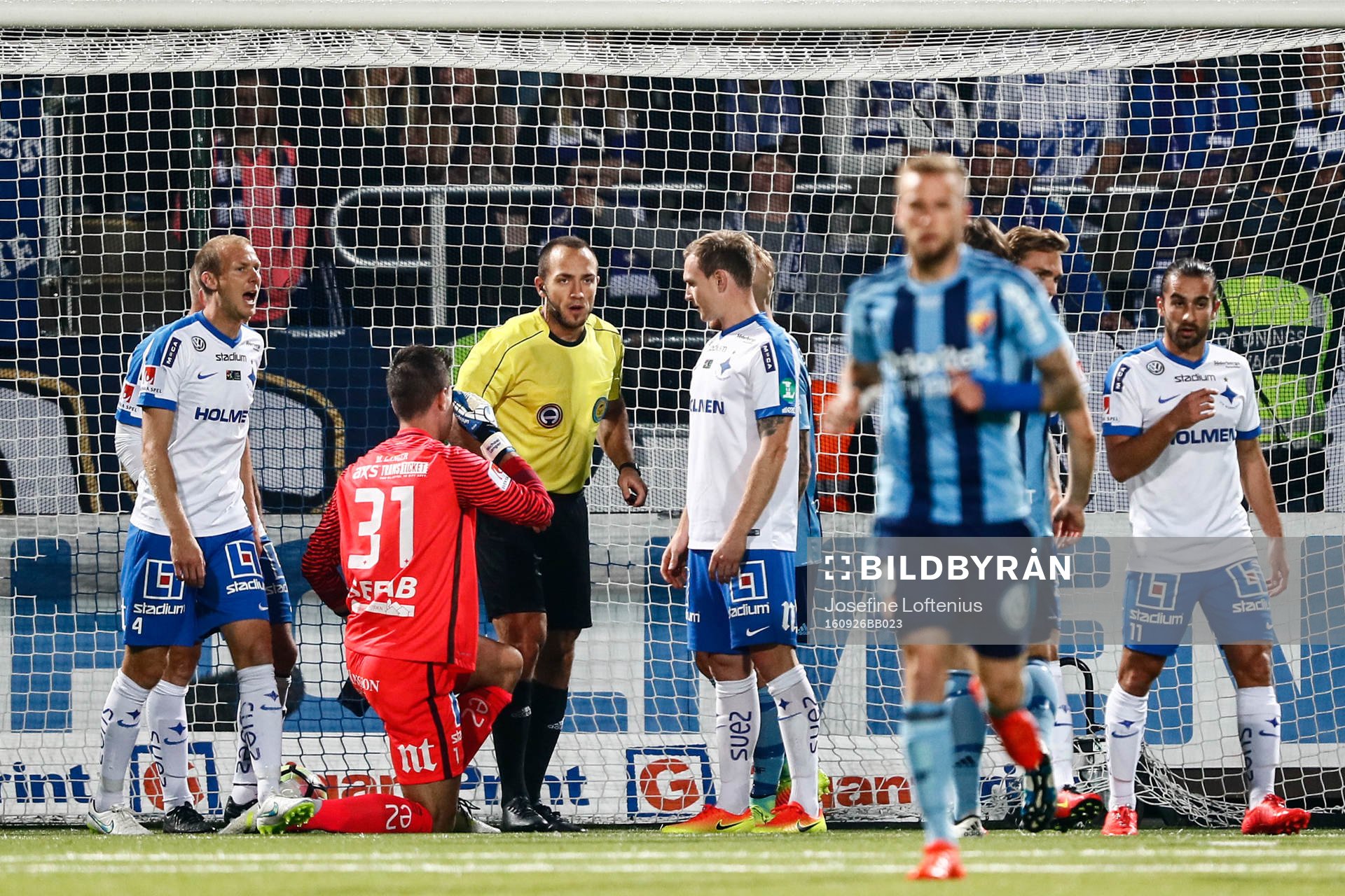 Domare Kaspar Sjöberg diskuterar med spelarna om ett mål