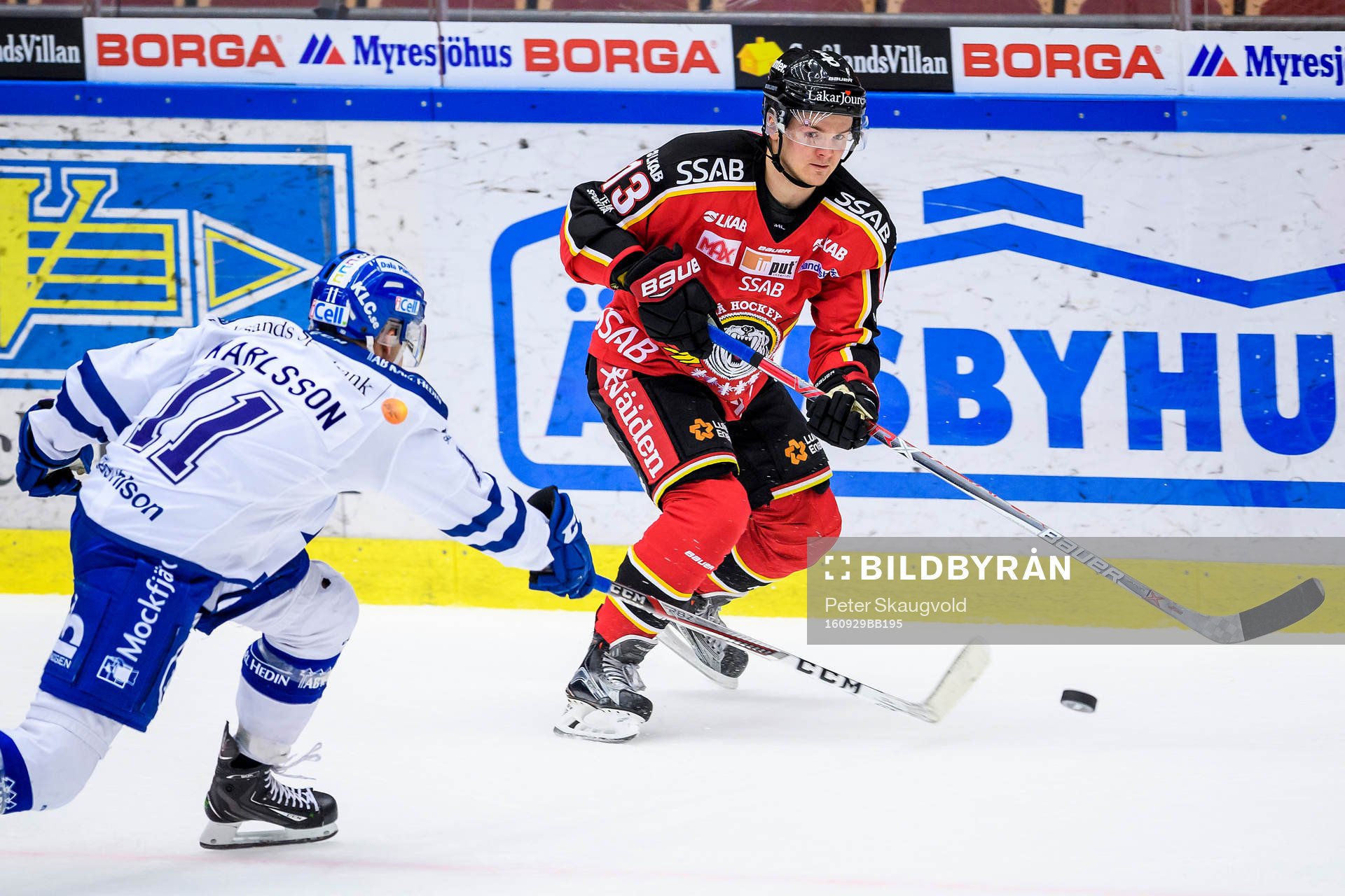Luleås Julius Junttila med pucken utmanas av Leksands