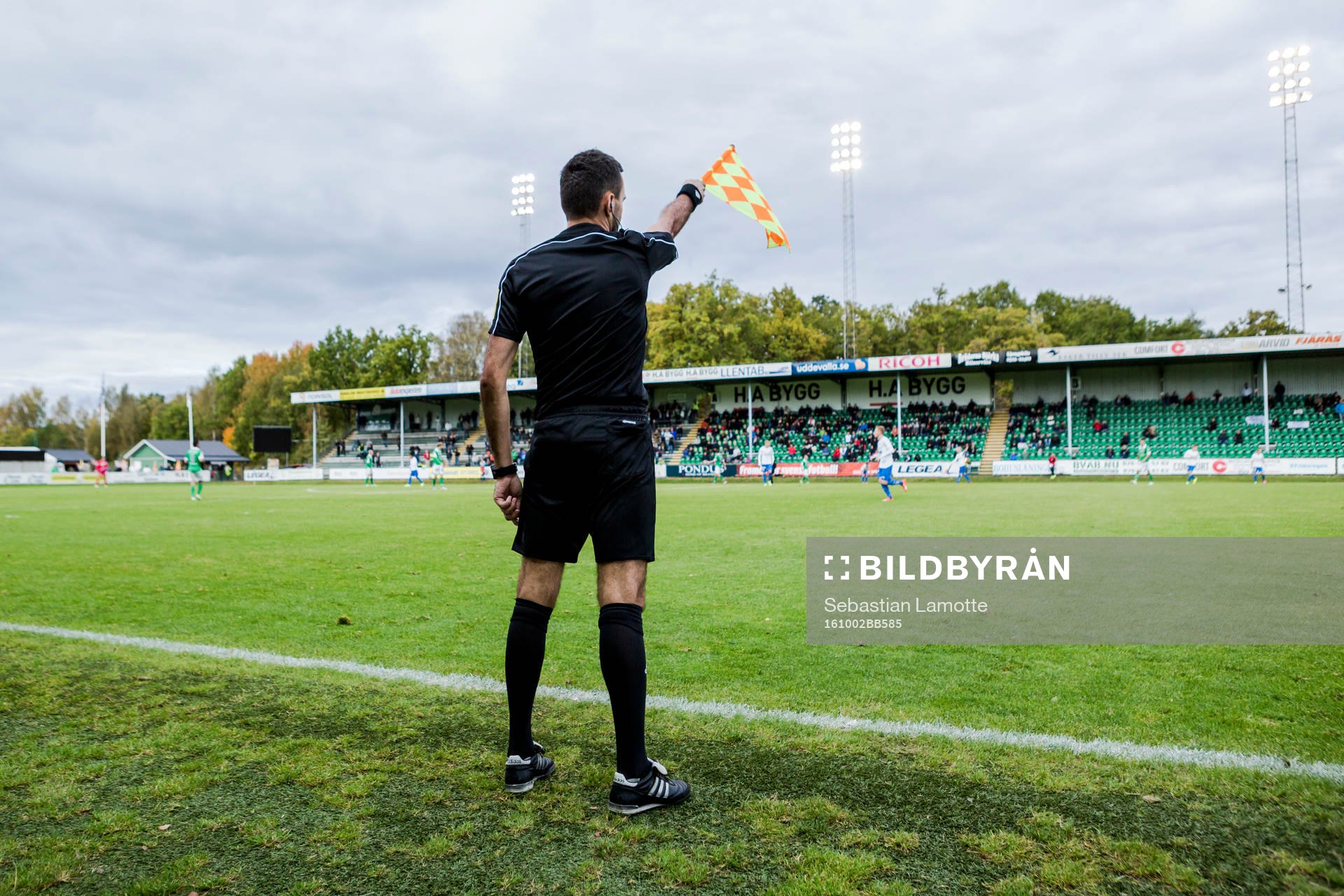 Den assisterande domaren vinkar för offside