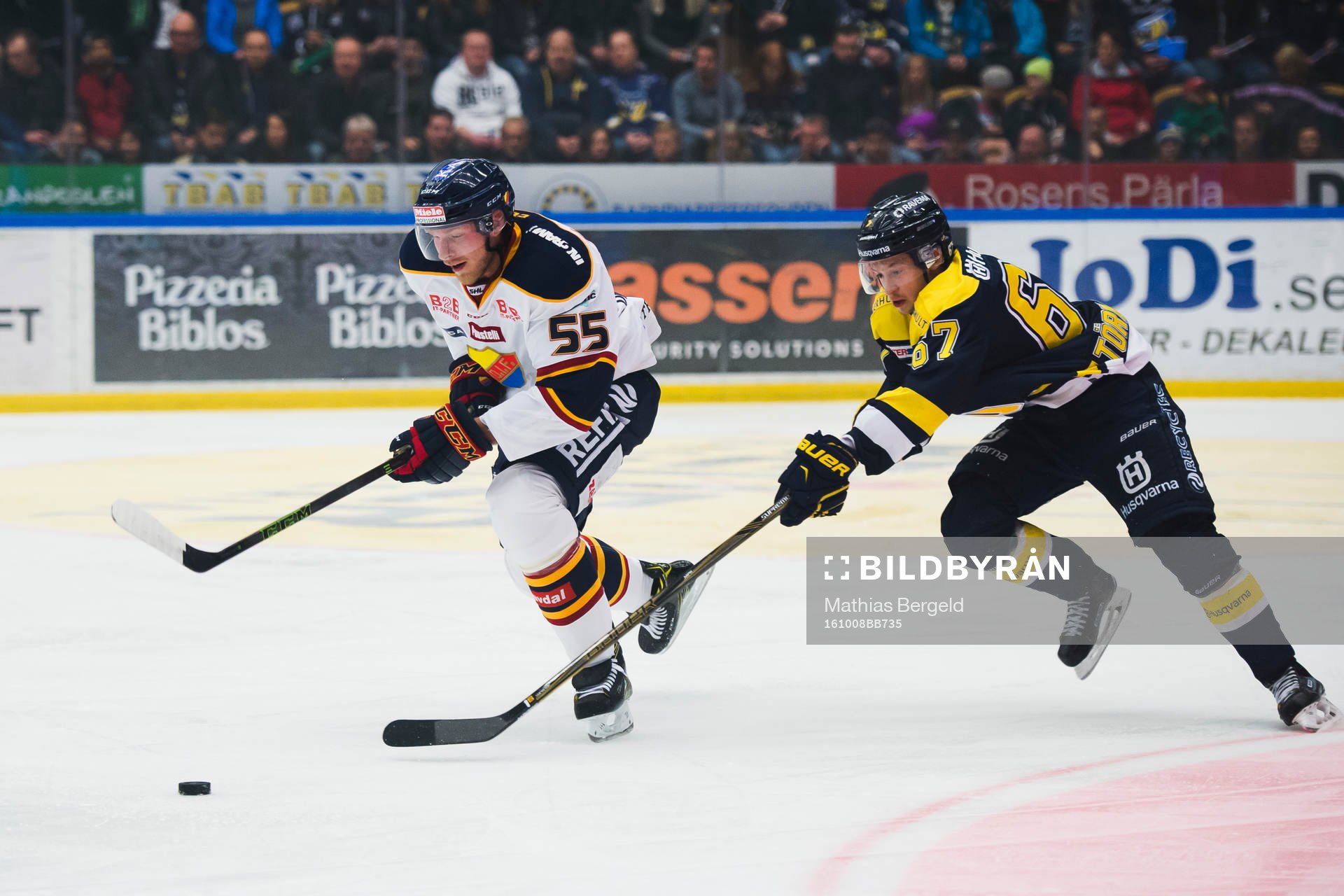 Djurgårdens Alexander Urbom driver pucken och jagas av