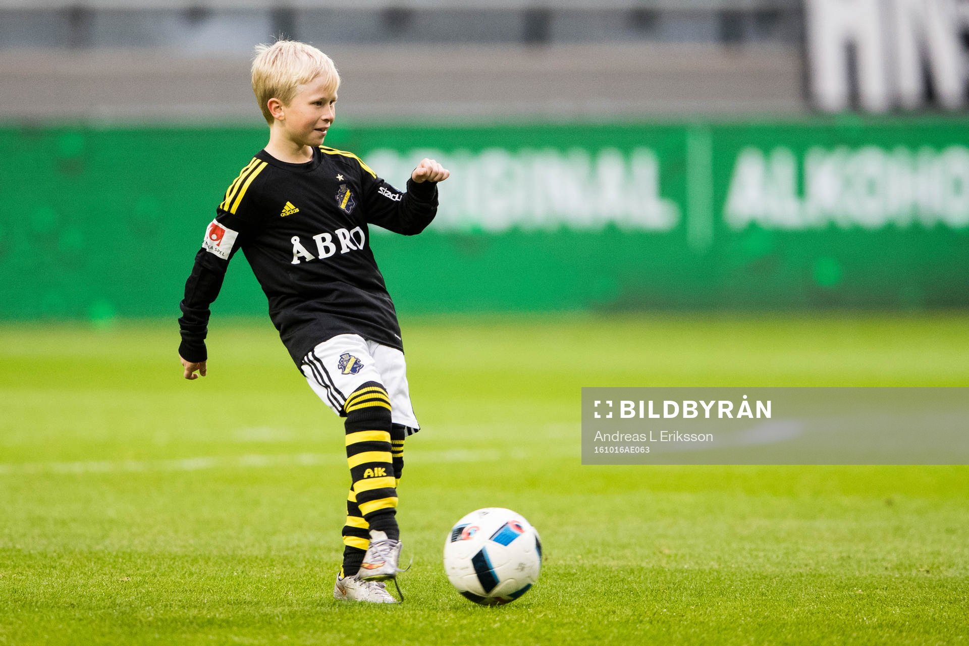 En knatte sparkar en boll innan fotbollsmatchen i
