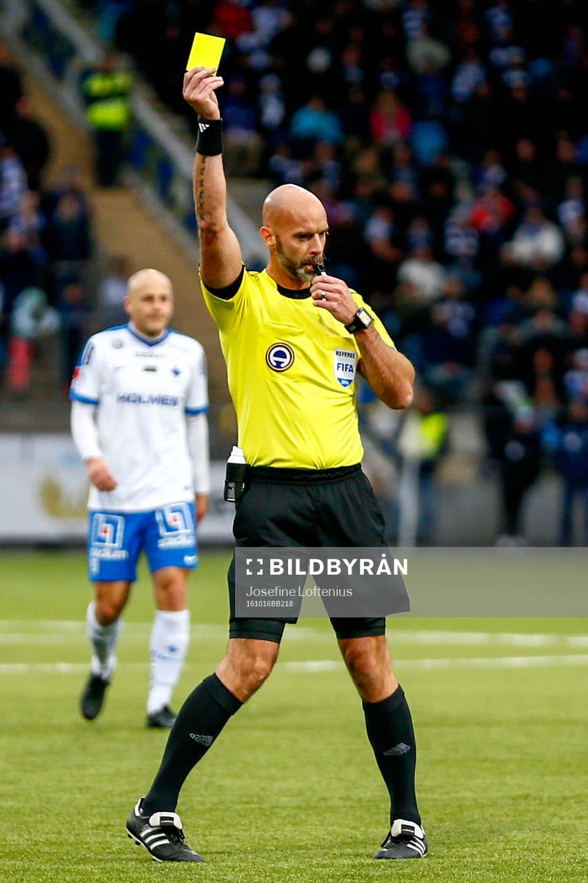 Domare Stefan Johannesson delar ut ett gult kort