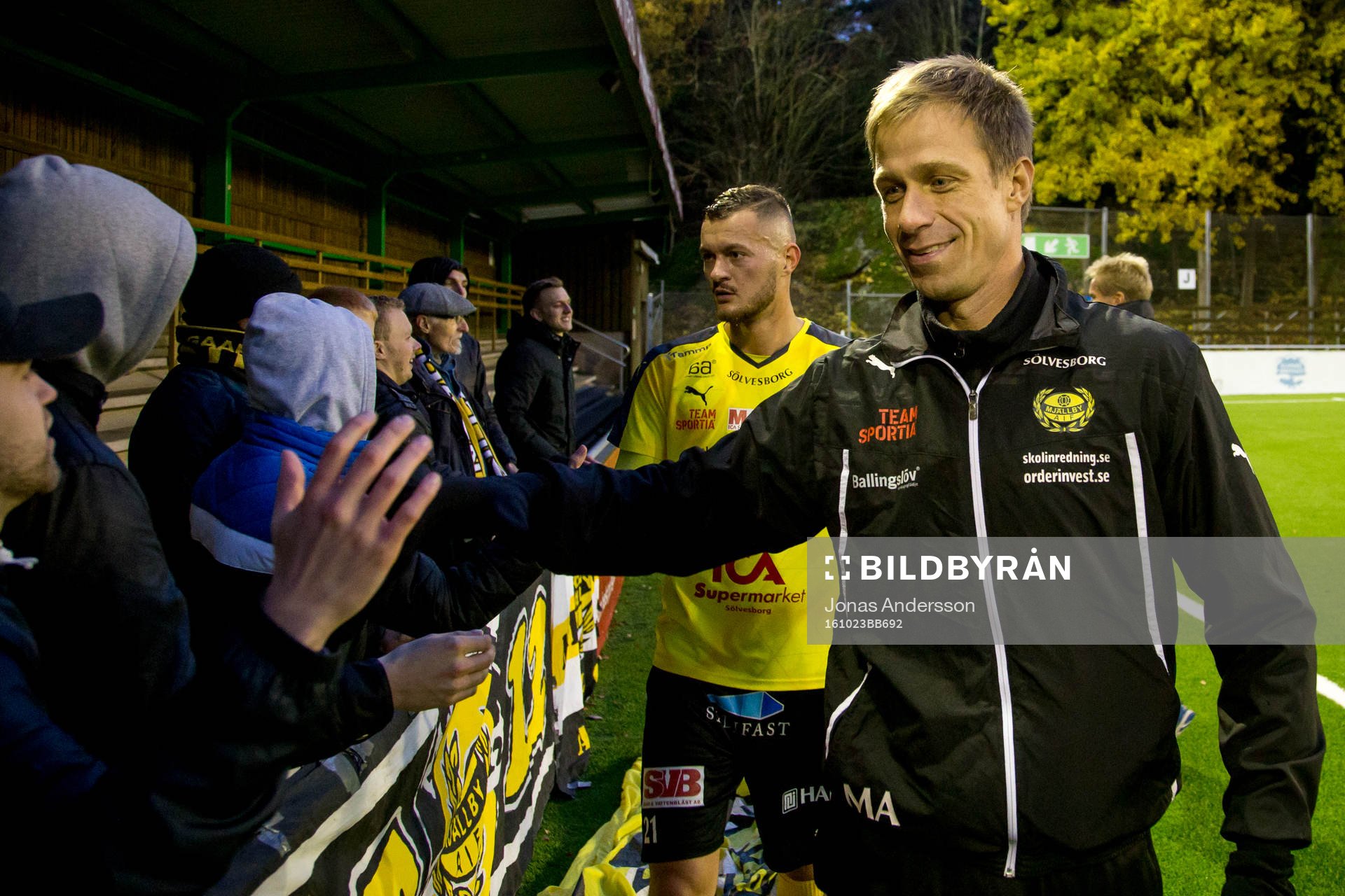 Mjällbys assisterande tränare Mattias Asper tackar fansen efter matchen under fotbollsmatchen i Division 1 södra mellan Utsikten och Mjällby den 23 oktober 2016 i Göteborg. 