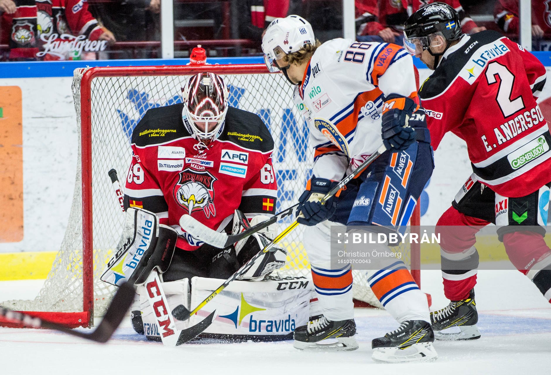 Växjös Adam Brodecki med pucken framför  Malmö Redhawks