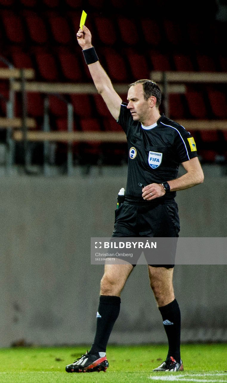 Domaren Jonas Eriksson håller upp gult kort